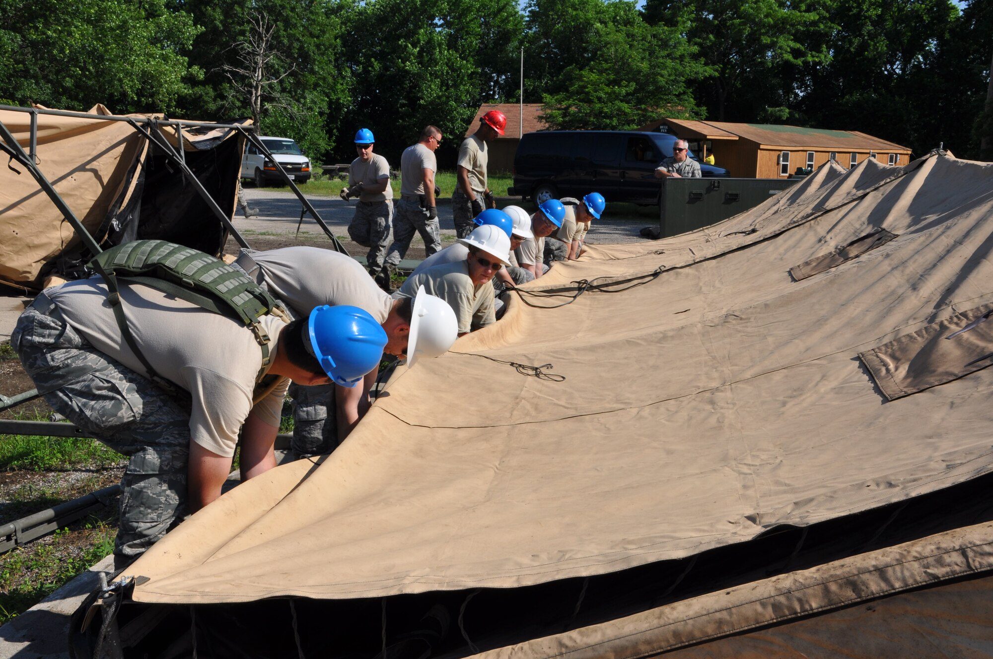 Members of the 442nd Civil Engineer Squadron prepare to lift the side of a temper tent during field training here, June 20, 2013. During the field training, members of 442nd CES set up and inventoried tents, prepared and manned defensive fighting positions. The 442nd CES is part of the 442nd Fighter Wing, an A-10 Thunderbolt II Air Force Reserve unit at Whiteman Air Force Base, Mo. (U.S. Air Force photo by Senior Airman Wesley Wright/ Released)