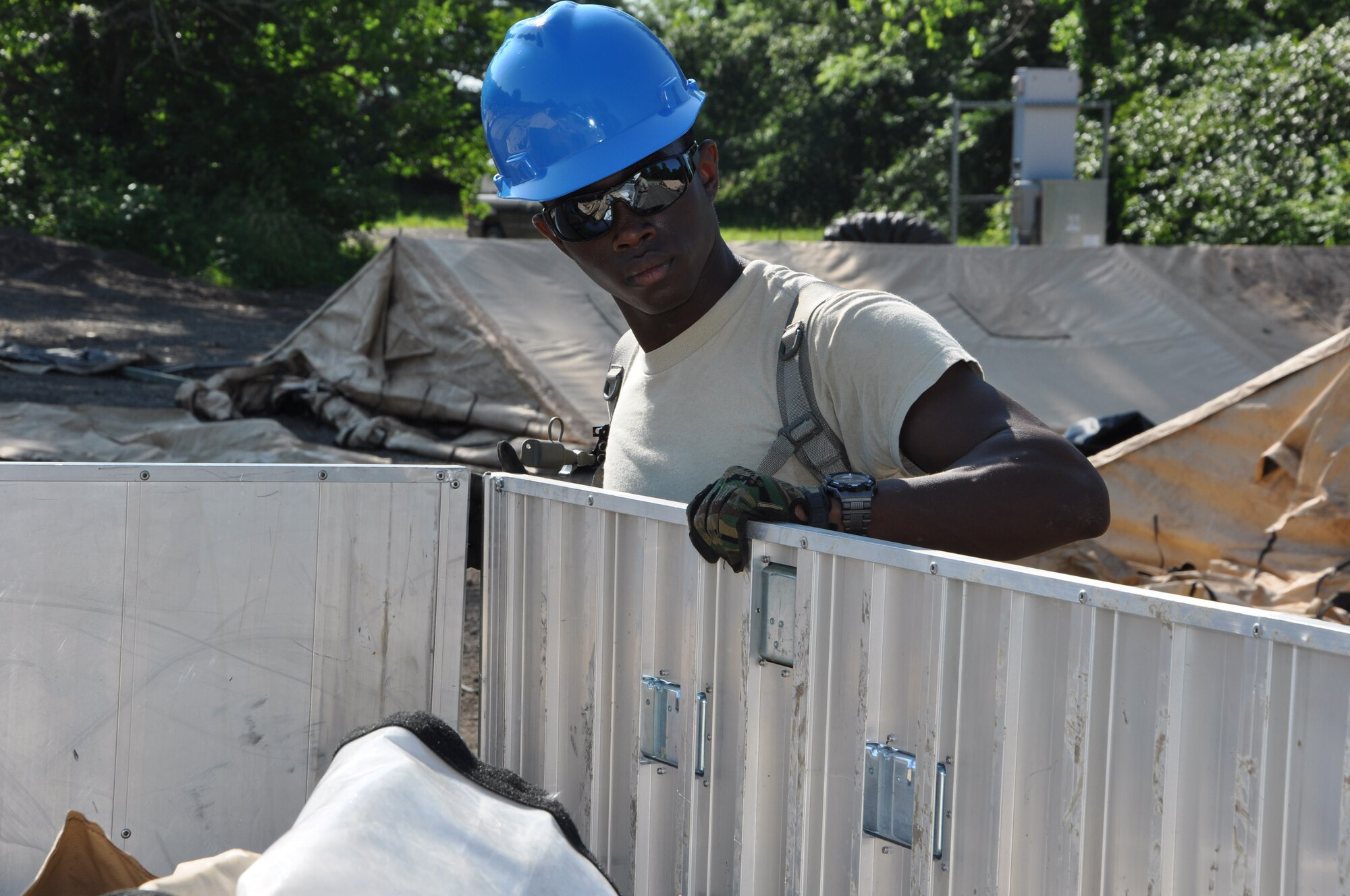 Senior Airman Dominique Knowles, 442nd Civil Engineer Squadron structures technician, places a door on a bin containing temper-tent components during field training here, June 20, 2013. During the field training, members of 442nd CES set up and inventoried tents, prepared and manned defensive fighting positions. The 442nd CES is part of the 442nd Fighter Wing, an A-10 Thunderbolt II Air Force Reserve unit at Whiteman Air Force Base, Mo. (U.S. Air Force photo by Senior Airman Wesley Wright/ Released)