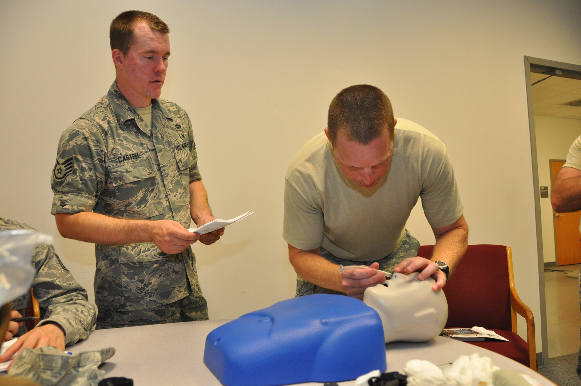 Capt. Troy Stanton, 442nd Civil Engineer Squadron officer (right), demonstrates how to insert a breathing tube, while Staff Sgt. David Casteel observes, during self-aid buddy care hands-on training, June 19, 2013. Stanton recently returned from a CE deployment to Afghanistan, where he put his SABC training into action to treat a soldier injured by a mortar round. The 442nd CES is part of the 442nd Fighter Wing, an A-10 Thunderbolt II Air Force Reserve unit at Whiteman Air Force Base, Mo. (U.S. Air Force photo by Senior Airman Wesley Wright/Released)