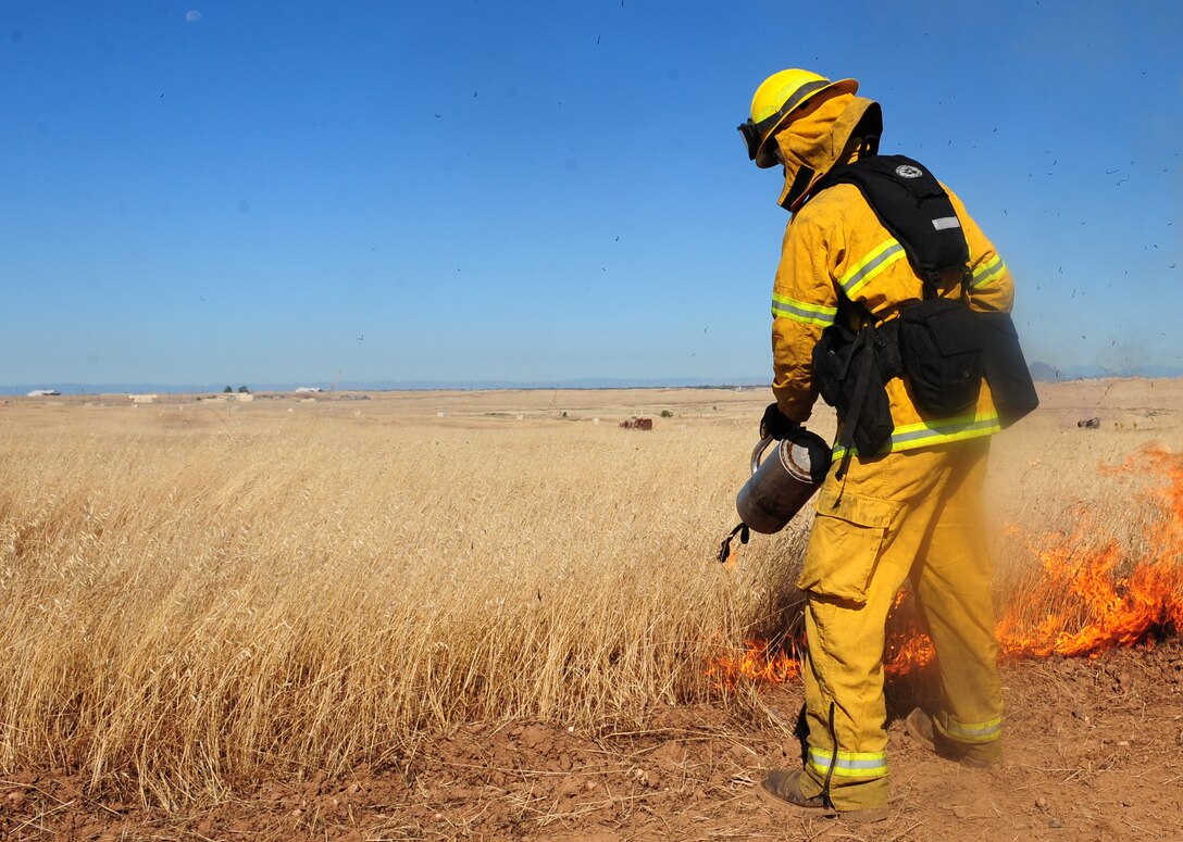 A Wheatland Calif., firefighter ignites a fire at the M-60 range on Beale Air Force Base, Calif., June 27, 2013. The Beale fire department combined forces with local fire departments to conduct a prescribed burn. (U.S. Air Force photo by Airman 1st Class Bobby Cummings/Released)