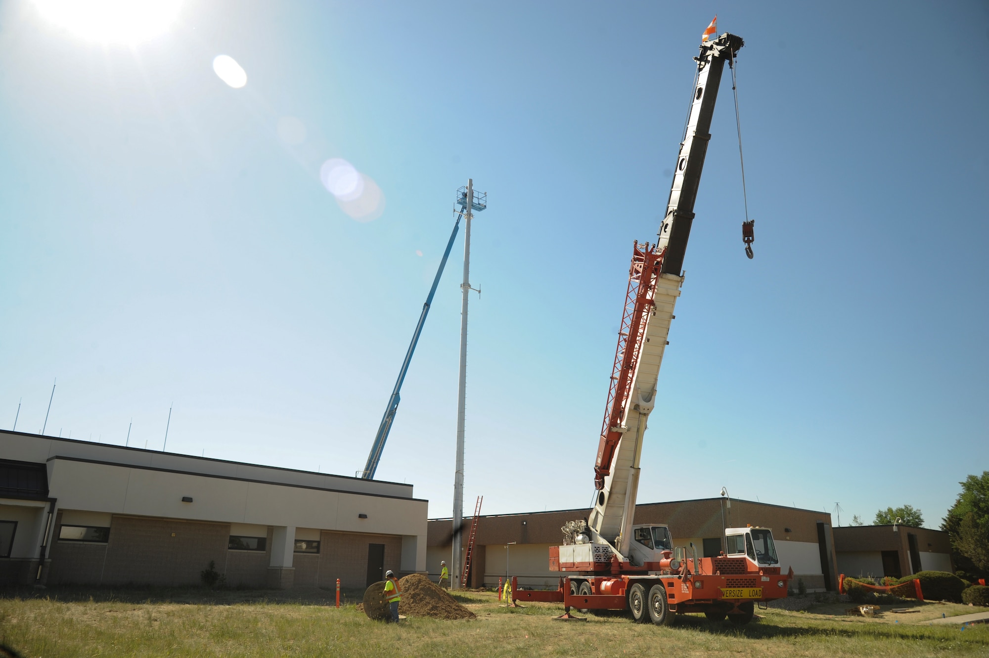 Members of the 460th Civil Engineer Squadron, 460th Space Communications Squadron and DWG and Associates worked together to install a new communication mono pole June 20-21, 2013, on Buckley Air Force Base, Colo. The new pole will serve as a backup and increase the distance of signals that can be transmitted from it. (U.S. Air Force photo by Staff Sgt. Christopher Gross/Released)