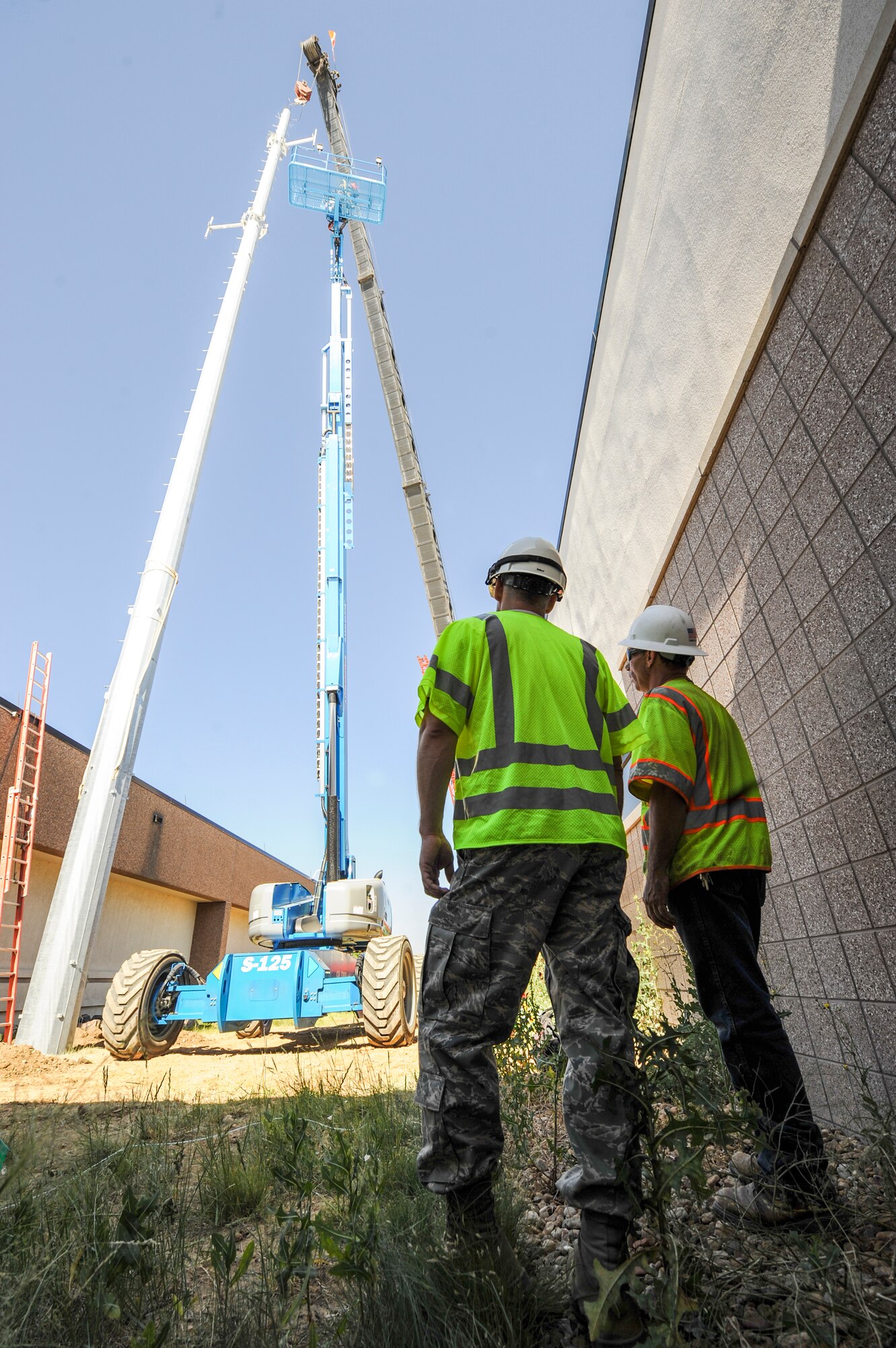 Maj. Gene Hockenberry, 460th Civil Engineer Squadron management consultant, left, talks with a DWG and Associates contractor June 21, 2013, on Buckley Air Force Base, Colo. Hockenberry oversaw the installation operations of a new communication mono pole. The 100-foot pole will serve as a backup for hand-held communication devices used primarily by first responders. (U.S. Air Force photo by Staff Sgt. Christopher Gross/Released)