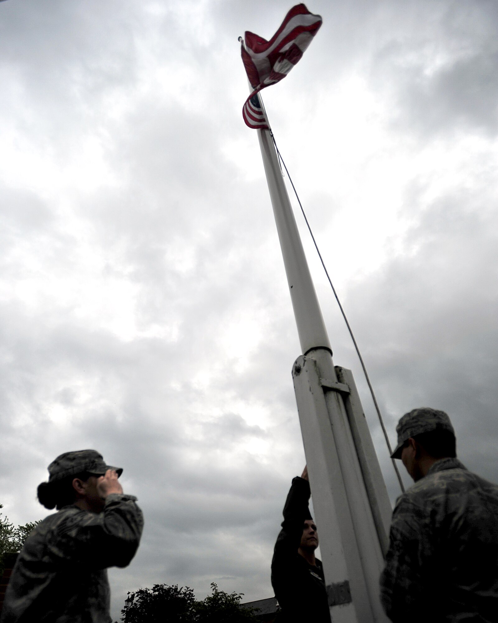 Team Mildenhall flag detail team members lower the U.S. flag during the monthly retreat ceremony June 28, 2013, on RAF Mildenhall, England.  The monthly retreat ceremony pays respect to both the U.S. flag and Royal Air Force ensign while symbolizing the official end to the duty day. (U.S. Air Force photo/Master Sgt Brian M. Boisvert/Released)