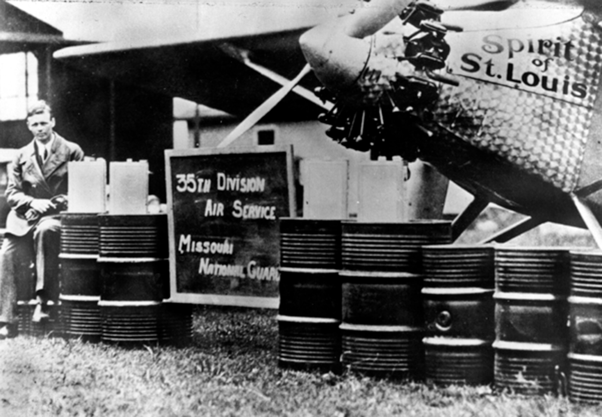 Aviator Capt. Charles Lindbergh, 110th Observation Squadron, 35th Division, Missouri National Guard (now 131st Bomb Wing, Missouri Air National Guard) poses beside the "Spirit of Saint Louis" at Robertson Field with a representation of how much fuel was required to complete his historic 33 1/2 solo flight from New York to Paris in the "Spirit of Saint Louis" on May 21, 1927.  He had to seek permission from his commanders at the 110th to make this flight.  (131st Bomb Wing file photo/RELEASED)