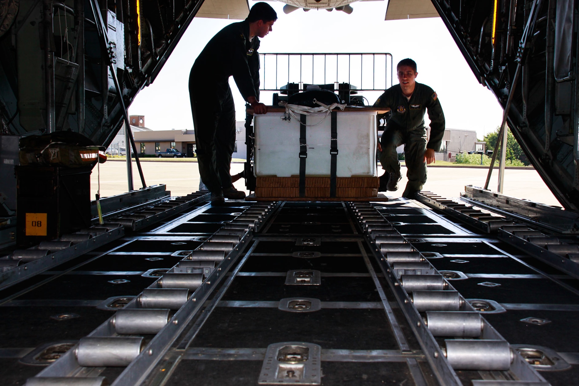 Senior Airmen Jake Johnston and Codey Wentz, 911th Airlift Wing loadmasters, load a Low Cost Low Altitude bundle (LC/LA) on the back of a C-130, June 4, 2013, at the Pittsburgh International Airport Air Reserve Station. (U.S. Air Force photo by Senior Airman Justyne Obeldobel)
