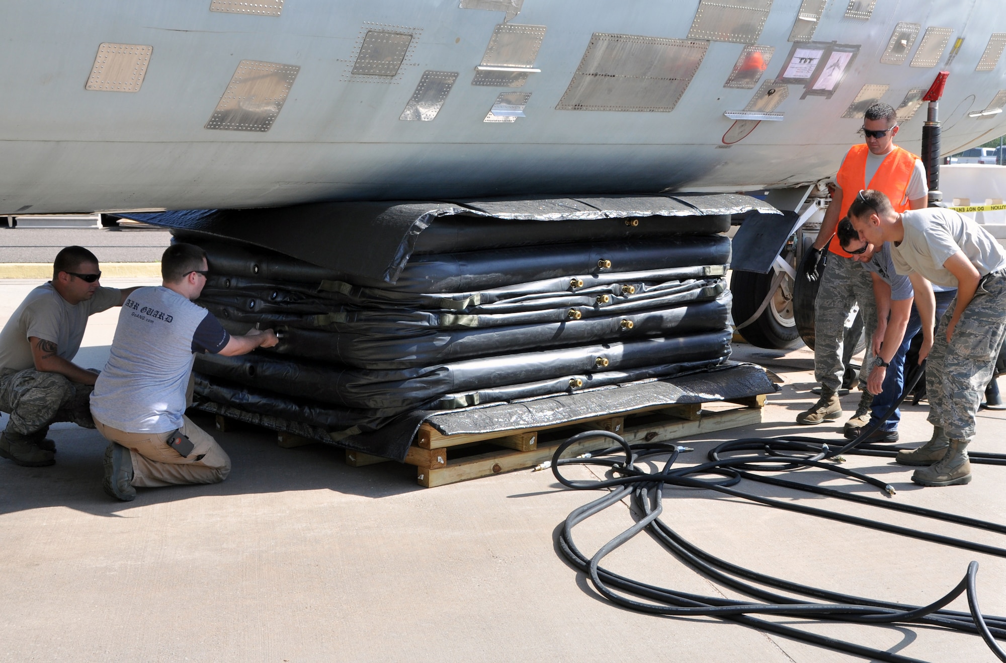 Members of the 137th and 507th Maintenance Squadrons use a airbag to lift a training aircraft after a simulated nose gear failure. This training is historic as it is the first time the Reserve/Guard association team has simulated a KC-135 nose gear failure using a real aircraft.  (U.S. Air Force photo/Senior Airman Mark Hybers)