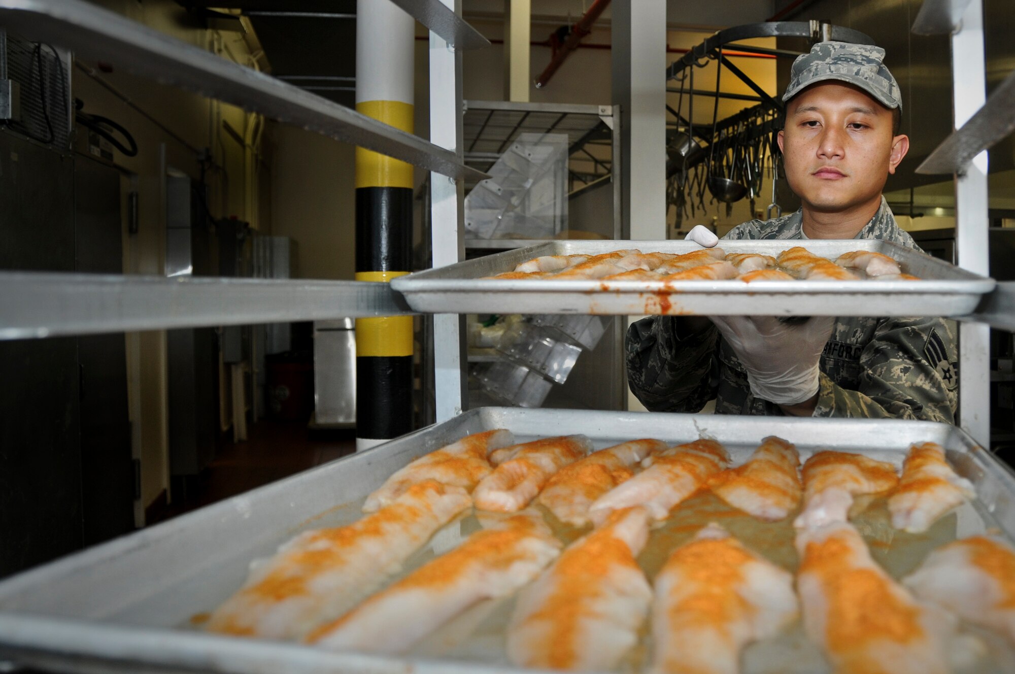 Senior Airman Giovanni Mendoza, 911th Force Support Squadron food services specialist, prepares trays of seafood for the lunch-time meal served during the unit training assembly, June 2, 2013, at the Pittsburgh International Airport Air Reserve Station. (U.S. Air Force photo by Senior Airman Joshua J. Seybert)