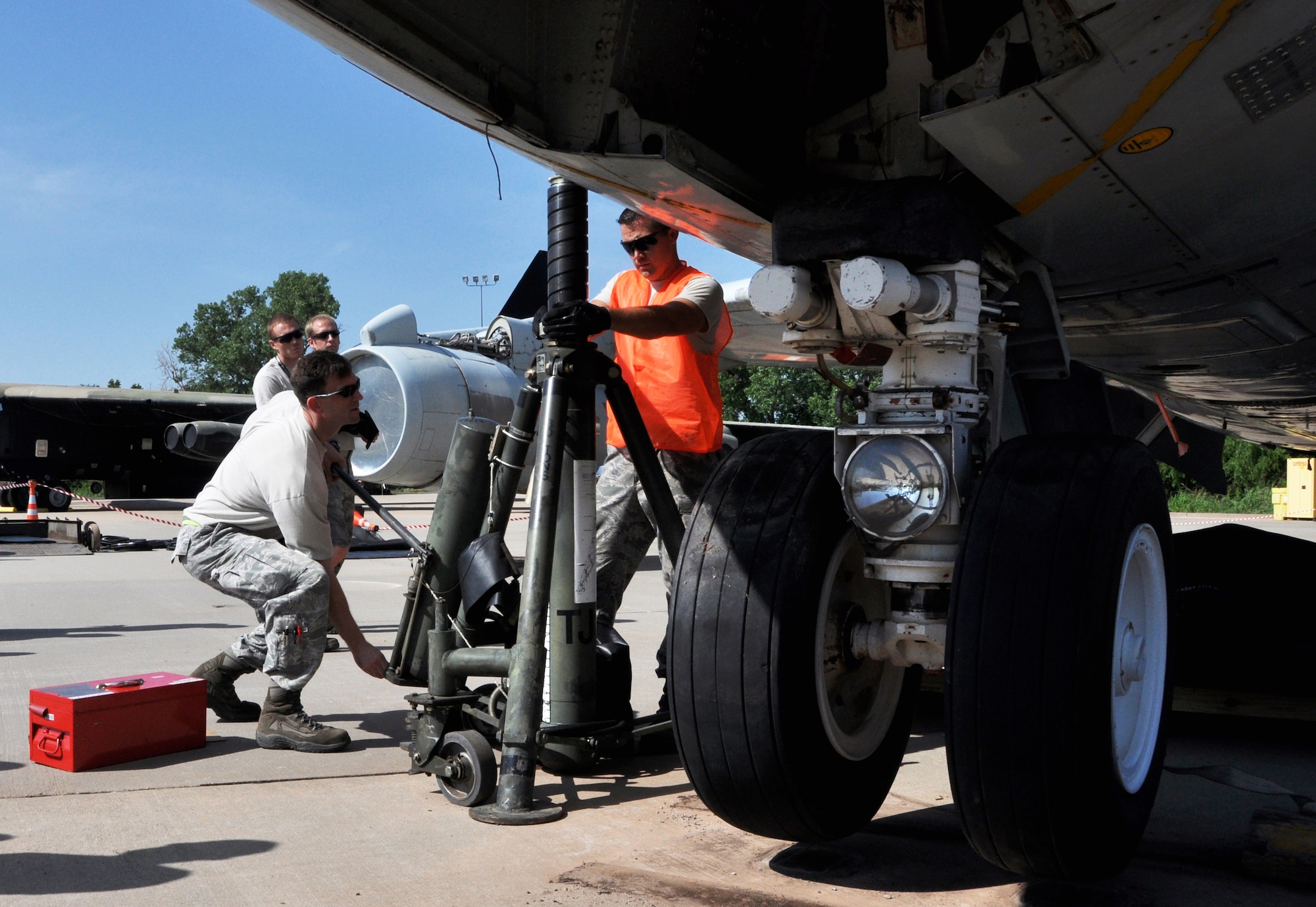 Tech. Sgt. Chad Dinwiddie, 513th Maintenance Squadron (left) and Staff Sgt. Chris Coats of the 137th Maintenance Squadron, Oklahoma Air National Guard, lower a KC-135 Stratotanker back to the ground.  This is the final stage of the nose gear failure exercise conducted by the 137th and 507th Maintenance Squadrons at the Aircraft Battle Damage Repair facility June 20. (U.S. Air Force Photo/Senior Airman Mark Hybers)