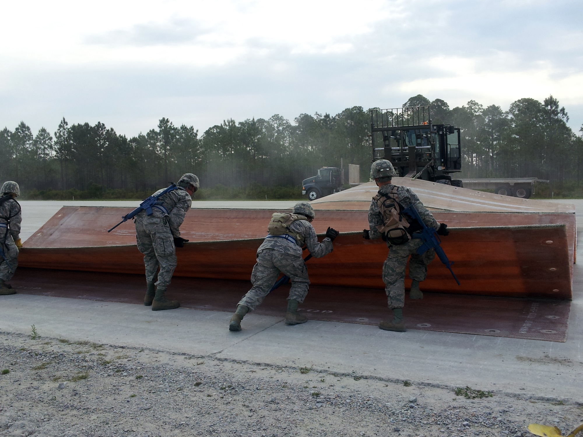 Civil engineers participating in a Silver Flag exercise at Tyndall Air Force Base, Fla., place runway matting down to establish a temporary airfield supporting simulated F-16 and C-130 operations. Twenty Nine 507th Civil Engineer Squadron Reservists “deployed” to the location to train in setting up and establishing a fully operational base in a contingency environment. (U.S. Air Force Photo/Lt. Col. Patricia Pettine)

