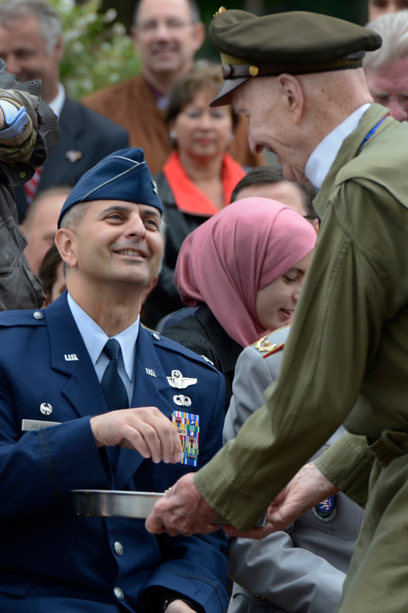 SPANGDAHLEM AIR BASE, Germany – U.S. Air Force Col. David Julazadeh, 52nd Fighter Wing commander accepts candy from Retired U.S. Air Force Col. Gail Halvorsen, known as the “candy bomber” during the 65th anniversary of the Berlin Airlift at the Berlin Airlift Memorial in Frankfurt, Germany June 26, 2013. During the Berlin Airlift, U.S., British and French cargo planes dropped more than 20 tons of candy to children in west Berlin. (U.S. Air Force photo by Staff Sgt. Christopher Ruano/Released)