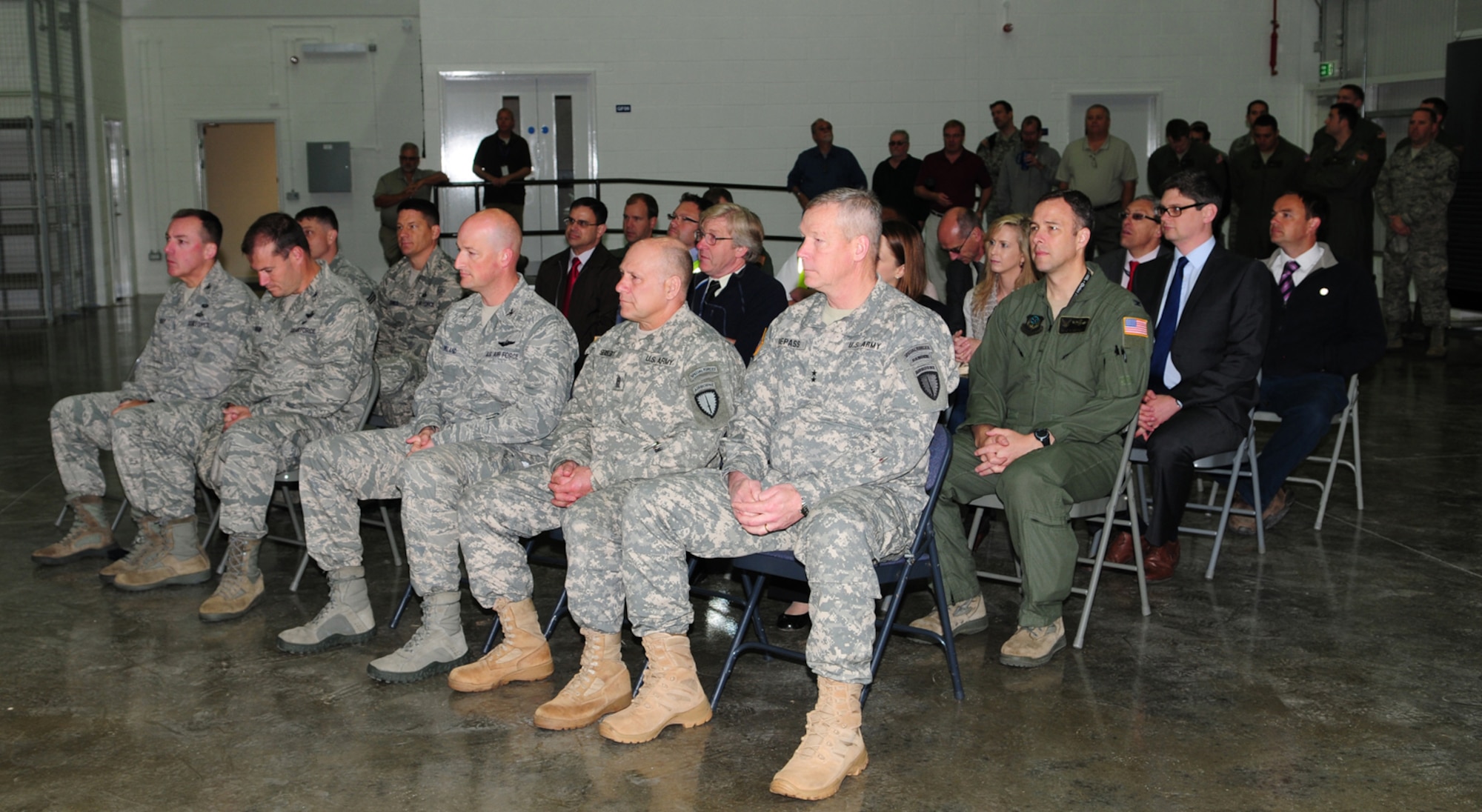 Distinguished visitors, including leadership from the 100th Air Refueling Wing, 352nd Special Operations Group and Special Operations Command-Europe, Stuttgart, Germany, wait for the start of the ribbon cutting ceremony for the CV-22 Osprey simulator facility June 21, 2013, on RAF Mildenhall, England. Once in-place, the actual simulator will provide CV-22 pilots a vital training tool in gaining currency, proficiency and experience. (U.S. Air Force photo by Karen Abeyasekere/Released)