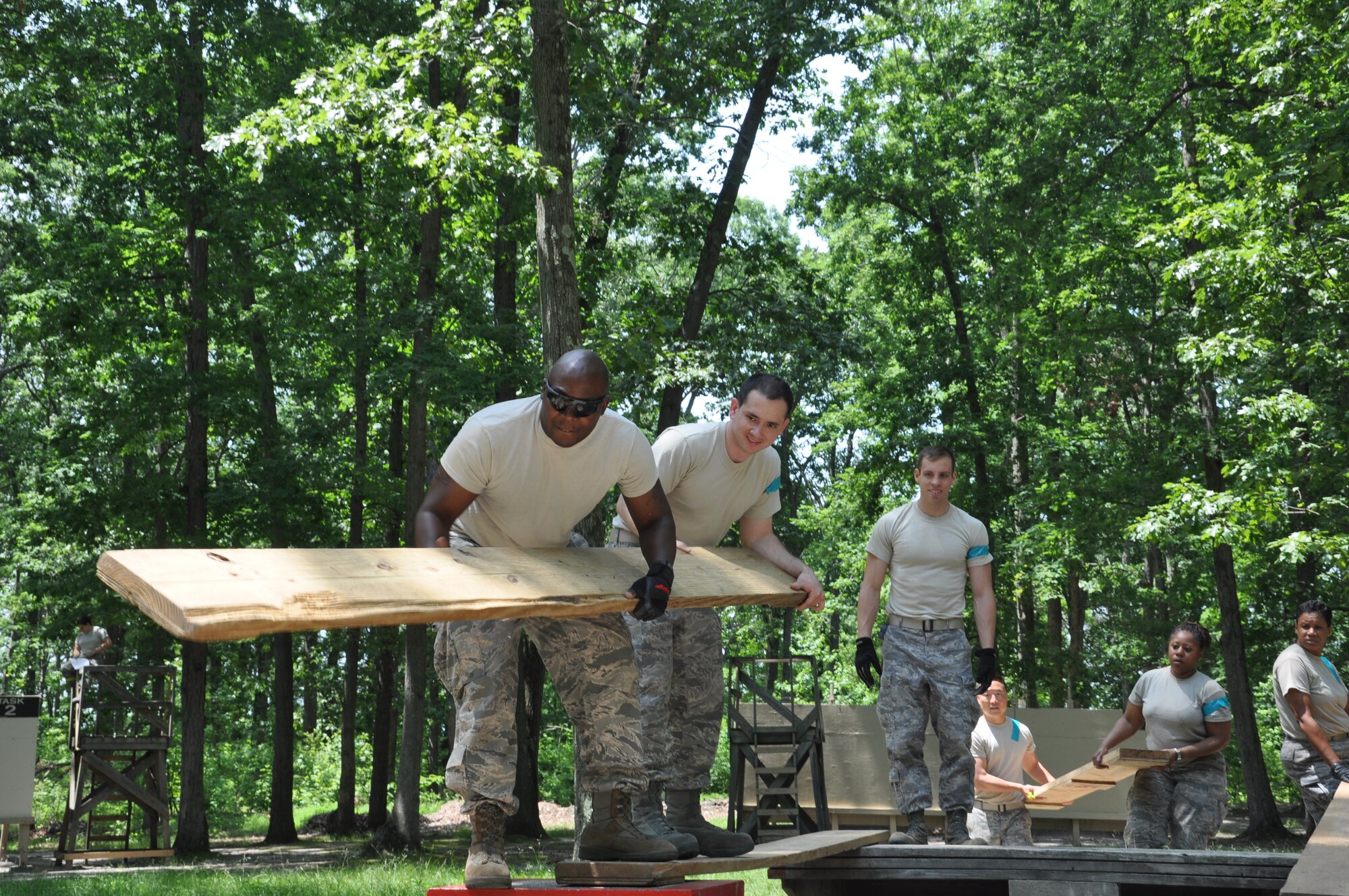 Members of Team Flash Five work frantically on the Leadership Development Course by using wooden planks to create a bridge during the 514th Air Mobility Wing Human Resource Development Council (HRDC) mentoring workshop held here, Jun. 22-23. (U.S. Air Force photo by Tech. Sgt. Jonathan E. White)