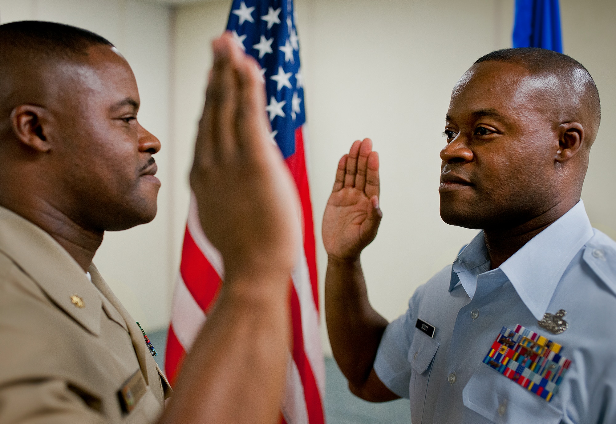 Navy Lt. Cdr. Anthony Scott reenlists his twin brother Master Sgt. Antone Scott, 96th Logistics Readiness Squadron, for his fifth enlistment into the Air Force June 27 at Eglin Air Force Base, Fla.  Due to their schedules and service commitments, this was the first time the twins had been able to participate in the time-honored tradition.  When Anthony became a naval officer, his brother Antone was the first one to salute him.  (U.S. Air Force photo/Samuel King Jr.)