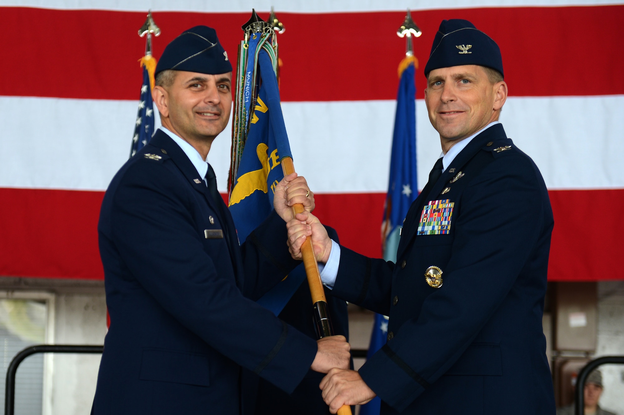 SPANGDAHLEM AIR BASE, Germany -- U.S. Air Force Col. Robert Winkler, 52nd Operations Group commander, right, receives the 52nd guidon from U.S. Air Force Col. David Julazadeh, 52nd Fighter Wing commander, during a change of command ceremony June 28, 2013. Winkler accepted command from U.S. Air Force Col. David Lyons, the outgoing 52nd OG commander. A change of command is a military tradition that represents a formal transfer of authority and responsibility for a unit from one commanding officer to another. (U.S. Air Force photo by Airman 1st Class Gustavo Castillo/Released) 