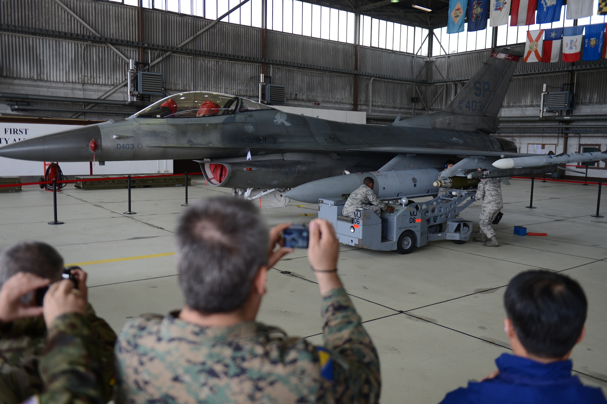 SPANGDAHLEM AIR BASE, Germany — Airmen demonstrate an aircraft weapons load on an F-16 Fighting Falcon fighter aircraft during the Vienna Document 11 visit June 27, 2013.  Throughout the tour, Vienna Document delegates witnessed how Spangdahlem performs its daily operations, promoting a culture of understanding to the 34 nations involved in the visit. Adhering to the Vienna Document agreement showcases the U.S. government’s commitment to enduring partnerships. (U.S. Air Force photo by Airman 1st Class Gustavo Castillo/Released)