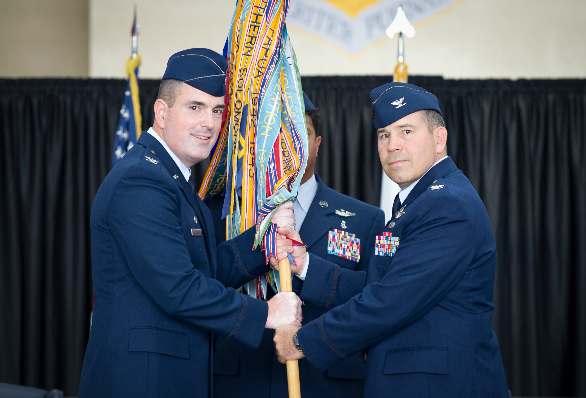 Col. Robert Blagg, 374th Operations Group commander, receives the guidon from Col. Mark August, 374th Airlift Wing commander, during the 374th OG change of command ceremony at Yokota Air Base, Japan, June 24, 2013. Blagg replaced Col. David Gould as commander of the 374 OG. (U.S. Air Force photo by Staff Sgt. Stacy Moless)