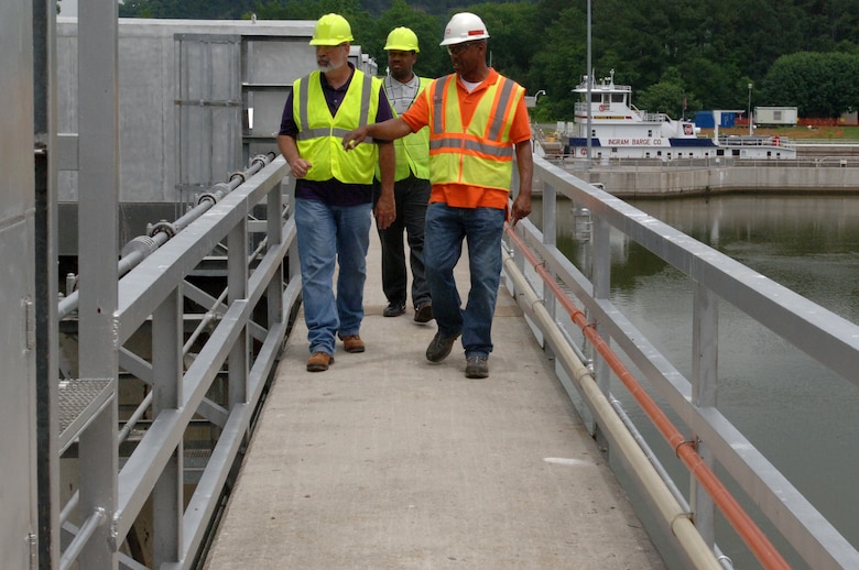 Construction Engineering Technician Victory Young (Right), U.S. Army Corps of Engineers Nashville District Mid Cumberland Construction Office, walks Victor Bright (Center), history teacher, and Harold Cunningham, construction teacher, across the top of Cheatham Dam in Ashland City, Tenn., during a tour June 6, 2013.  The Cane Ridge High School teachers were participating in an externship with the Corps to develop project based learning curriculum.