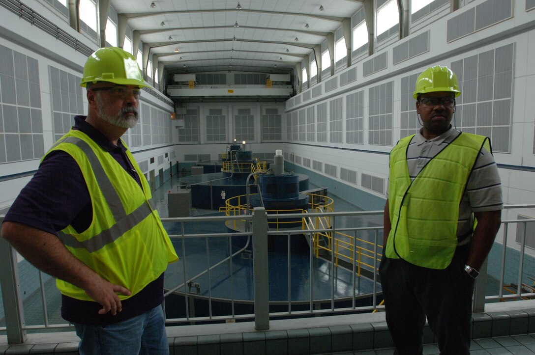 Victor Bright (Right), history teacher, and Harold Cunningham, construction teacher, learn about how the Corps produces clean energy during a tour of the Cheatham Dam Hydropower Plant in Charlotte, Tenn., during a tour June 6, 2013.  The Cane Ridge High School teachers were participating in an externship with the Corps to develop project based learning curriculum.