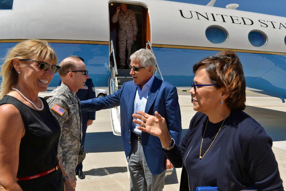 Defense Secretary Chuck Hagel, right, chats with Army Gen. Charles Jacoby Jr., commander of U.S. Northern Command and North American Aerospace Defense Command, while Amy Dubie, left, wife of Lt. Gen Mike Dubie, Northcom's deputy commander, greets Hagel's wife, Lilibet, as they arrive on Peterson Air Force Base in Colorado Springs, Colo., June 27, 2013.