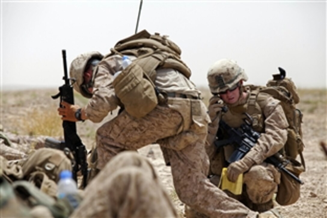 U.S. Marine Corps 1st Lt. Stephen Desmond, right, relays his positions to his leadership team by radio while conducting Operation Northern Lion in Mohammad Abad village in Helmand province, Afghanistan, June 24, 2013. Desmond is assigned to Georgian Liaison Team-9. 