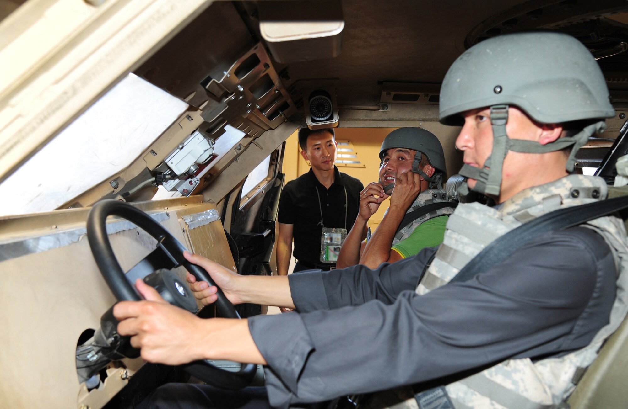 Capt. Mu Kim, 376th Air Expeditionary Wing Theater Security Cooperation division social cultural branch chief does a final safety check on visitors during a tour of the Mine Resistant Ambush Protected vehicle rollover simulator at Transit Center at Manas, Kyrgyzstan, June 25, 2013. Kim is deployed from Wright-Patterson Air Force Base, Ohio and he is a native of Seoul, Korea. (U.S. Air Force photo/Staff Sgt. Krystie Martinez)