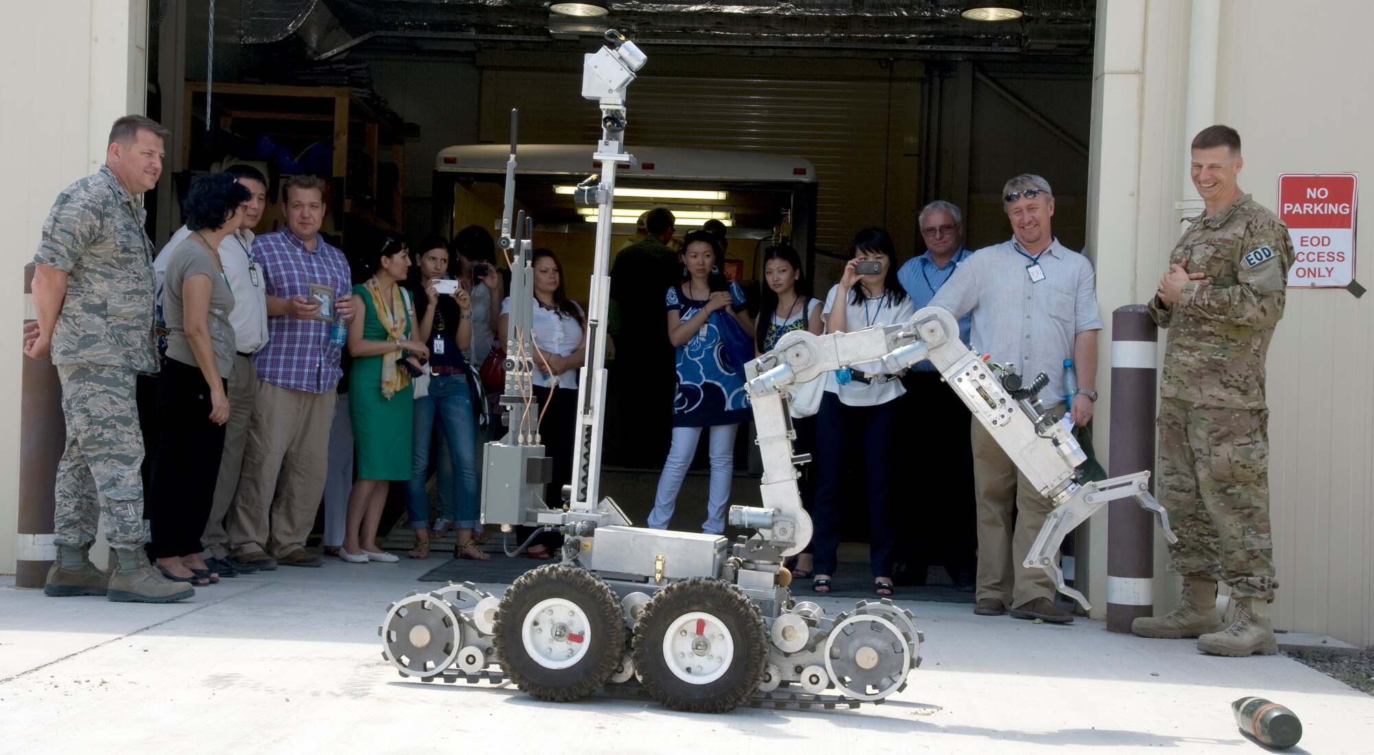 Staff Sgt. Michael Ault, explosive ordnance disposal craftsman, 376th Expeditionary Civil Engineer Squadron training section, right, briefs the capabilities of an EOD robot to visitors during a tour of Transit Center at Manas, Kyrgyzstan, June 25, 2013. In order to help TCM achieve the goal of transparent operations, the 376th Air Expeditionary Wing Theater Security Cooperation division hosts two to three tours a month. Ault is deployed from Aviano Air Base, Italy and he is a native of Austin, Texas. (U.S. Air Force photo/Staff Sgt. Krystie Martinez)