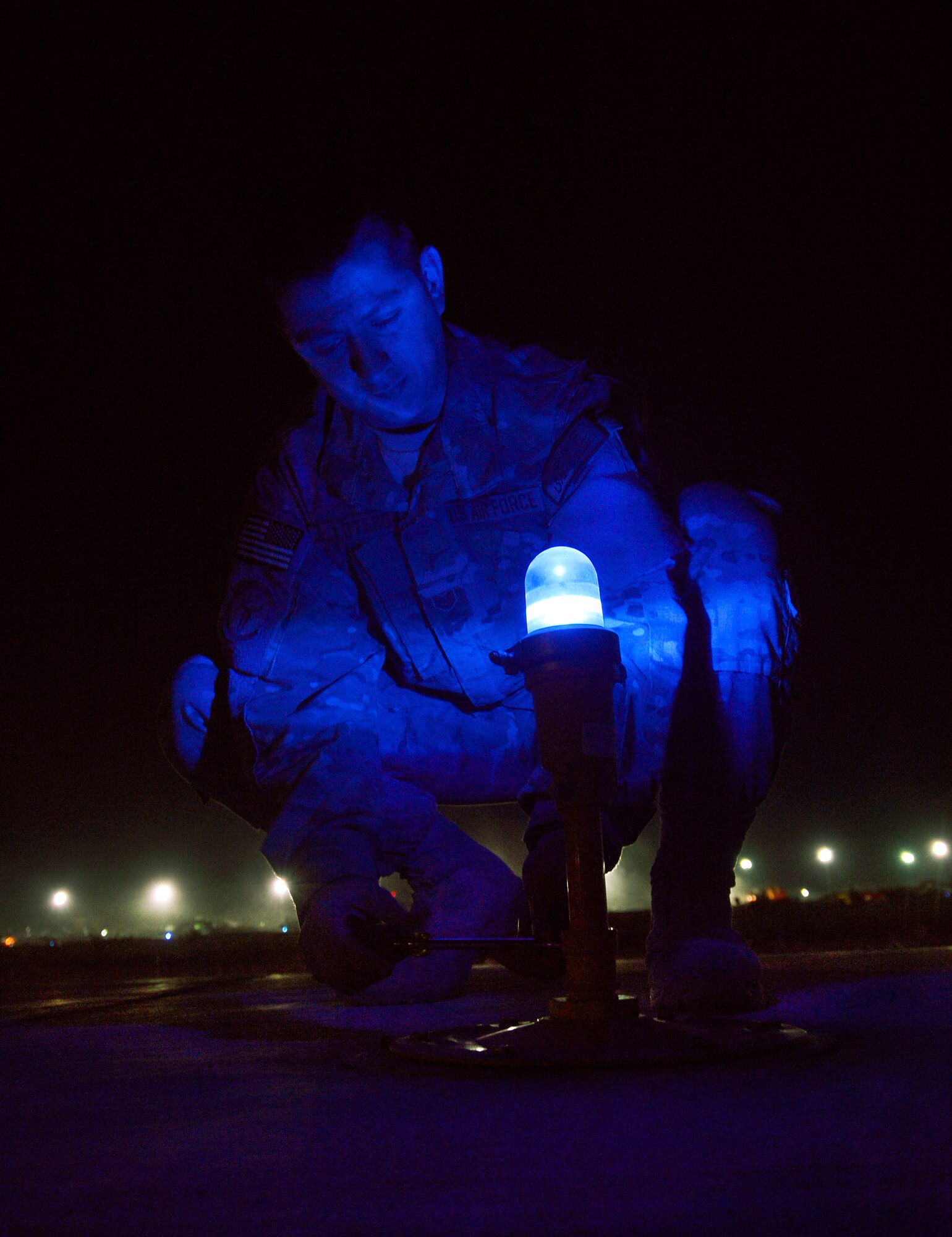 Tech. Sgt. Justin Lotero removes a taxiway light for inspection on Bagram Airfield, Afghanistan, June 6. Lotero, assigned to the 455th Expeditionary Civil Engineer Squadron electrical systems shop, is a member of a three-man airfield lighting team here working every night to maintain more than one-thousand lights spanning over one-million square feet on the flight line. He is deployed from the 117 Air Refueling Wing, Birmingham, Ala. (U.S. Air Force photo/Staff Sgt. Stephenie Wade)