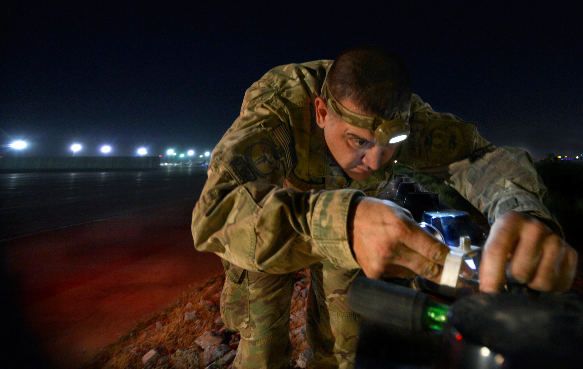 Staff Sgt. Paul Izyk replaces a bulb in a runway ramp sign on Bagram Airfield, Afghanistan, June 6. Izyk, assigned to the 455th Expeditionary Civil Engineer Squadron electrical systems shop, is a member of a three-man airfield lighting team working every night to maintain all the lights on the Department of Defense’s single busiest runway, transiting more than two-thousand aircraft movements per a month.  Izyk is deployed from the 136 Airlift Wing, Fort Worth, Texas and a native of Oswego, N.Y. (U.S. Air Force photo/Stephenie Wade)