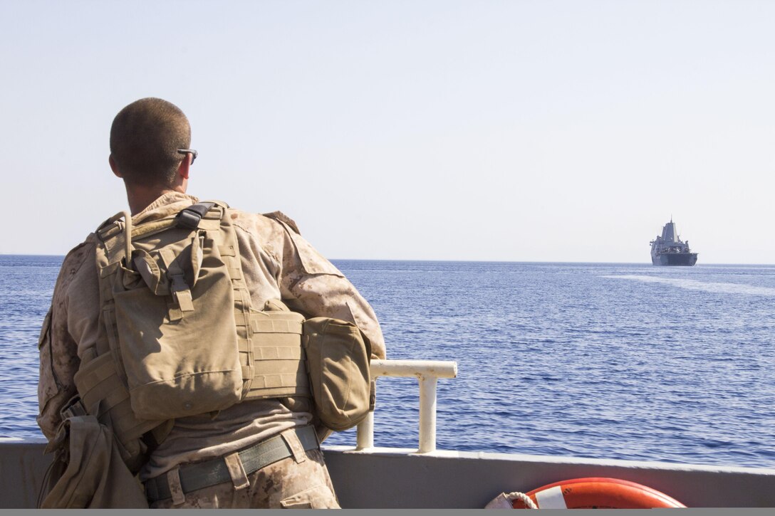 A U.S. Marine assigned to the 26th Marine Expeditionary Unit (MEU), is transported by a landing craft utility to the USS San Antonio (LPD 17), during the offload of Exercise Eager Lion 2013, Gulf of Aqaba, Jordan, June 21, 2013. Exercise Eager Lion 2013 is an annual, multinational exercise designed to strengthen military-to-military relationships and enhance security and stability in the region by responding to modern-day security scenarios. The 26th MEU is a Marine Air-Ground Task Force forward deployed to the U.S. 5th Fleet area of responsibility aboard the Kearsarge Amphibious Ready Group serving as a sea-based, expeditionary crisis response force capable of conducting amphibious operations across the full range of military operations. (U.S. Marine Corps photo by Lance Cpl. Juanenrique Owings, 26th MEU Combat Camera/Released)