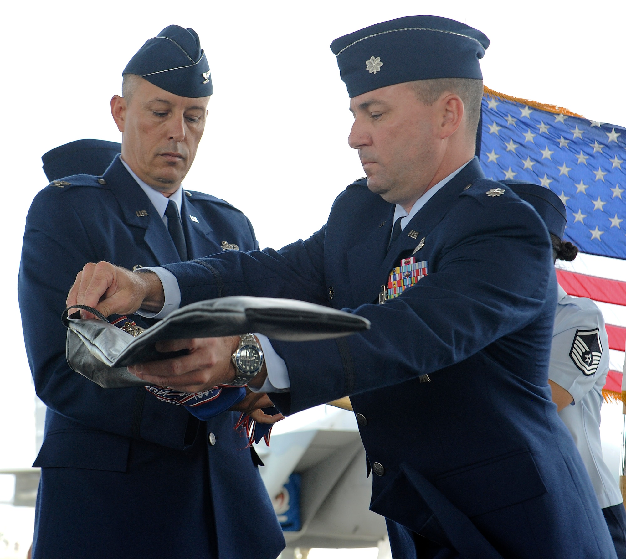 U.S. Air Force Lt. Col. Bryan Ford, 18th Maintenance Operations Squadron commander, cases the squadron's guidon with Col. Brian Beers, 18th Maintenance Group commander, during an inactivation ceremony on Kadena Air Base, Japan, June 27, 2013. The 18th MOS was responsible for administration, command and control, scheduling, analysis and quality assurance for aircraft assigned to Kadena. (U.S. Air Force photo by Airman 1st Class Malia Jenkins/Released)  
