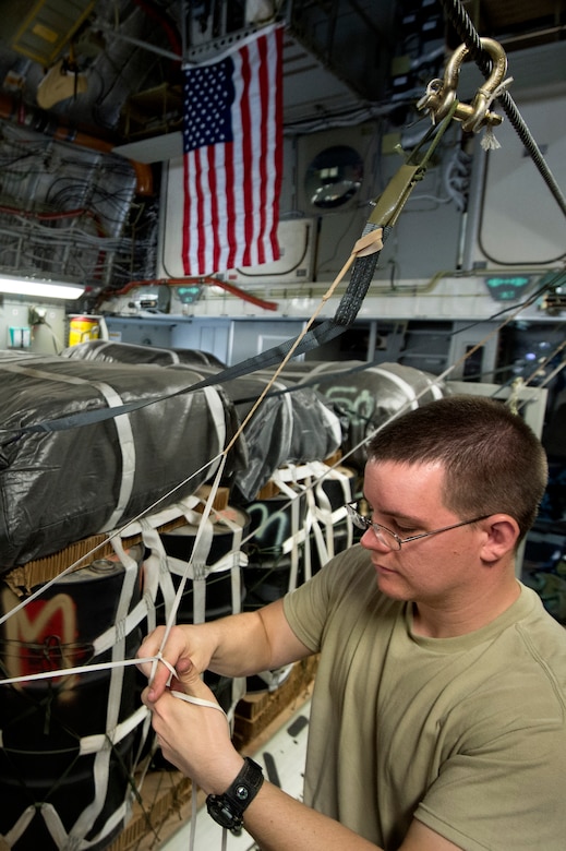 Staff Sgt. Derek Johnson, 451st Expeditionary Operations Support Squadron loadmaster, rigs a static line parachute on a C-17A Globemaster III for an airdrop out of Kandahar Airfield, Afghanistan, June 27, 2013. The Globemaster crew performed two airdrops in remote regions of Kandahar Province. Jonhson, hailing from Post Falls, Idaho, is deployed as a joint airdrop inspector from Little Rock Air Force Base, Ark. (U.S. Air Force Photo/Master Sgt. Ben Bloker)