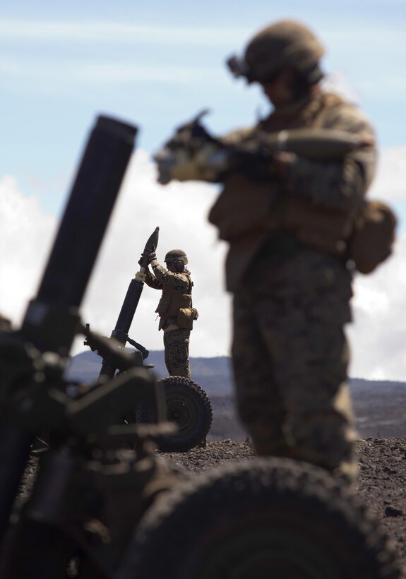 POHAKULOA TRAINING AREA, Hawaii - A field artilleryman with Alpha Battery, 1st Battalion, 12th Marine Regiment, loads a round into the M327 120 mm mortar system by stepping onto a metal crate and dropping ammunition into the barrel during Operation Spartan Fury at Pohakuloa Training Area, Hawaii, Feb. 21, 2013. The Alpha Battery Marines used the mortar system for the first time during the training exercise and were mentored by Marines from Bravo Battery to become familiar with the new weaponry.(U.S. Marine Corps photo by Lance Cpl. Nathan Knapke)