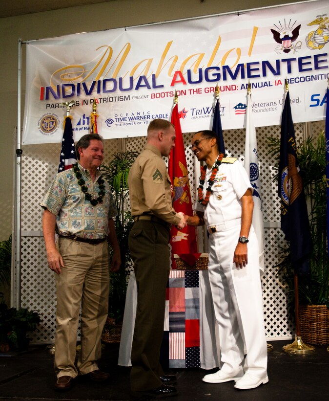 HONOLULU - Cpl. Brandon Jones, a rifleman with 1st Battalion, 3rd Marine Regiment and native of Romeo, N.Y., receives a coin from Adm. Cecil Haney, commander of U.S. Pacific Fleet and native of Washington, D.C., during a Navy League luncheon honoring the service of individual augmentees in support of overseas operations at the Ala Moana Hotel, Feb. 28. The Navy League dedicates itself to providing education programs for the American people on the U.S.’ role as a maritime power and the economic importance of free and open sea-lanes. (U.S. Marine Corps photo by Cpl. James A. Sauter) 
