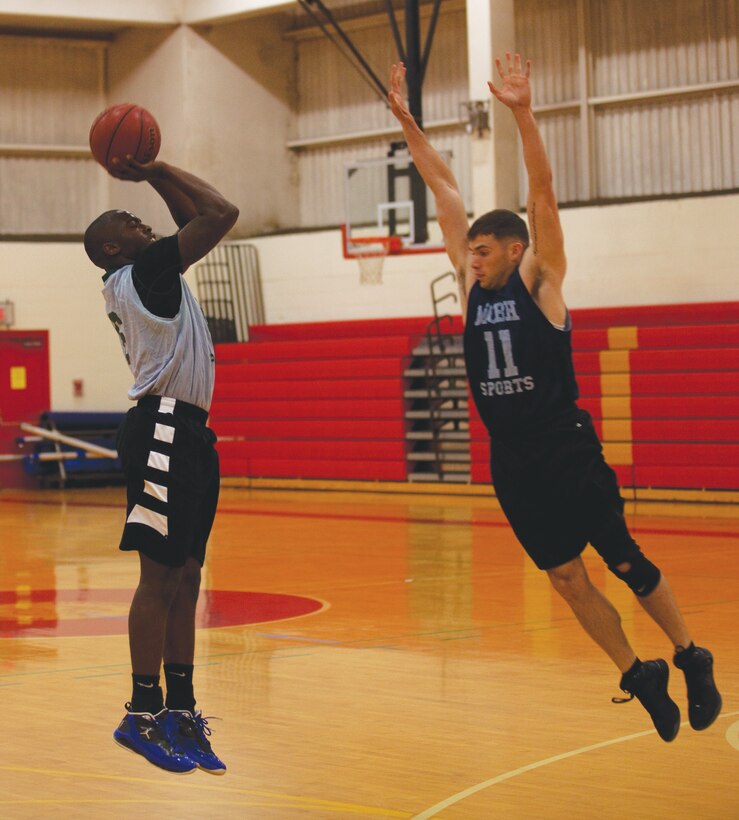 MARINE CORPS BASE HAWAII - Michael Canamore, a Marine Corps Air Station Kaneohe Bay guard, takes a three-point shot during an intramural basketball league game against the 3rd Radio Battalion Honey Badgers at Semper Fit Center gym, Feb. 27. “It was a hard-fought game and you could tell both of our teams wanted this victory,” Canamore said. “It was a little rough, to say the least, and we lost again, but it was a great game.”(U.S. Marine Corps photo by Lance Cpl. Jacob D. Barber)