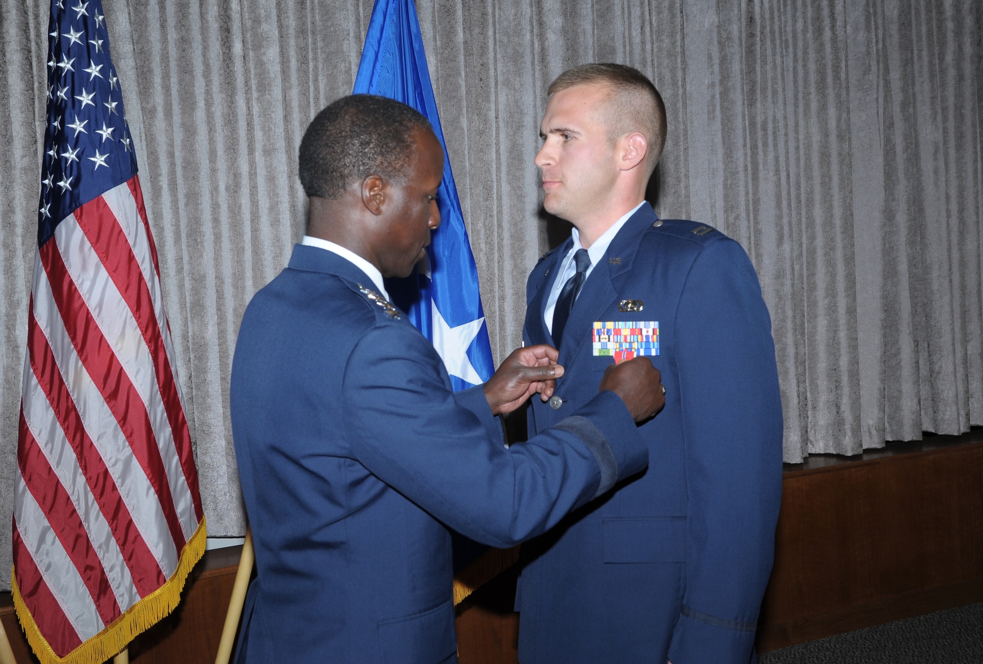 Capt. Collin C. Christopherson, received a Bronze Star Medal from Gen. Edward A. Rice Jr., Commander, Air Education and Training Command, Feb. 27, 2013, at Joint Base San Antonio-Randolph. Collin led five soldiers and airmen to defensive positions to protect six unarmed civilians and contractors. He led them through 86 indirect fire attacks and one direct attack in which insurgents used a vehicle-borne improvised explosive device at Forward Operating Base Shank, Afghanistan. (Air Force photo/Joel Martinez)

