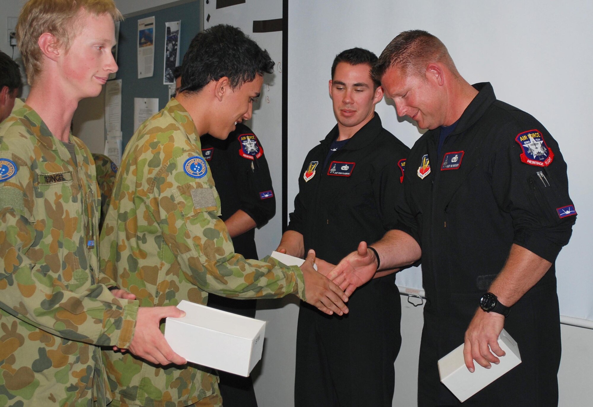 F-22 Raptor demonstration team members, from Langley Air Base, Virginia, exchange mementos with Army cadets from the Victoria Brigade on Feb. 28, 2013, at Monash Barracks, Dandenong South, Australia. The F-22 Raptor, demonstration team is performing at the Australian International Airshow 2013, which is one of the largest, biennial international trade shows in the Pacific. Approximately 220 U.S. service members along with the U.S. Air Force's F-22 Raptor, C-17 Globemaster III, F-16 Fighting Falcon, B-52 Stratofortress, and KC-135 Stratotanker are supporting AIA 2013, which allows a unique opportunity for the United States to showcase its aviation prowess and strengthen military-to-military ties with our Pacific allies and partners.. (U.S. Air Force photo by Capt. Natassia Cherne) 

