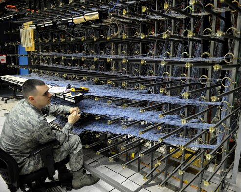 Airman 1st Class Dustin Lee, 2nd Communications Squadron cyber transport systems technician, searches for a wire on Barksdale Air Force Base, La., March 1. Airmen from the 2 CS were running cables to other buildings on base to ensure those buildings have telephone access. (U.S. Air Force photo/Airman 1st Class Benjamin Gonsier)