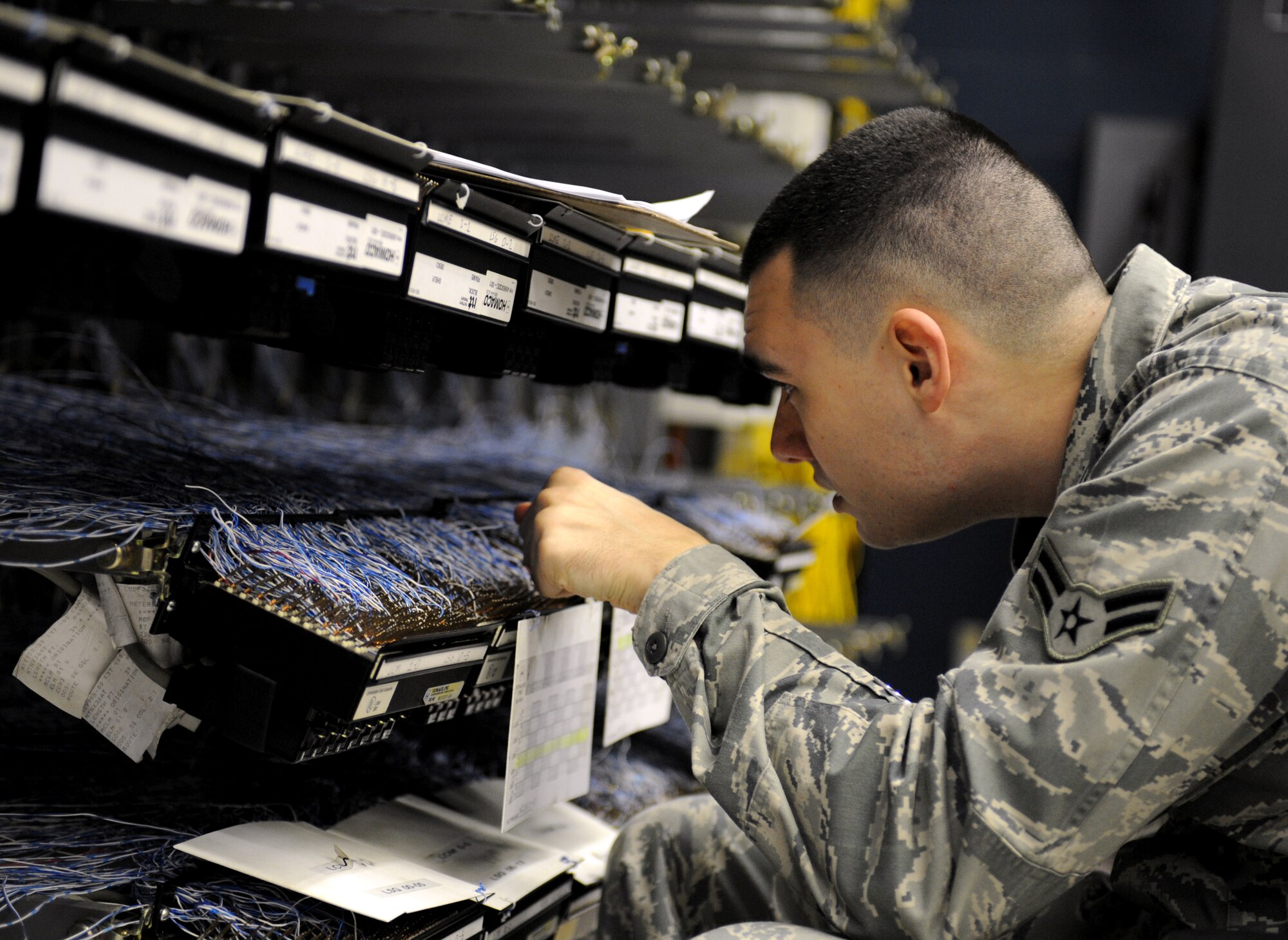 Airman 1st Class Dustin Lee, 2nd Communications Squadron cyber transport systems technician, looks for a wire to connect to a phone line on Barksdale Air Force Base, La., March 1. Airmen from the CTS section provide voice and data network support for the whole base. (U.S. Air Force photo/Airman 1st Class Benjamin Gonsier) 
