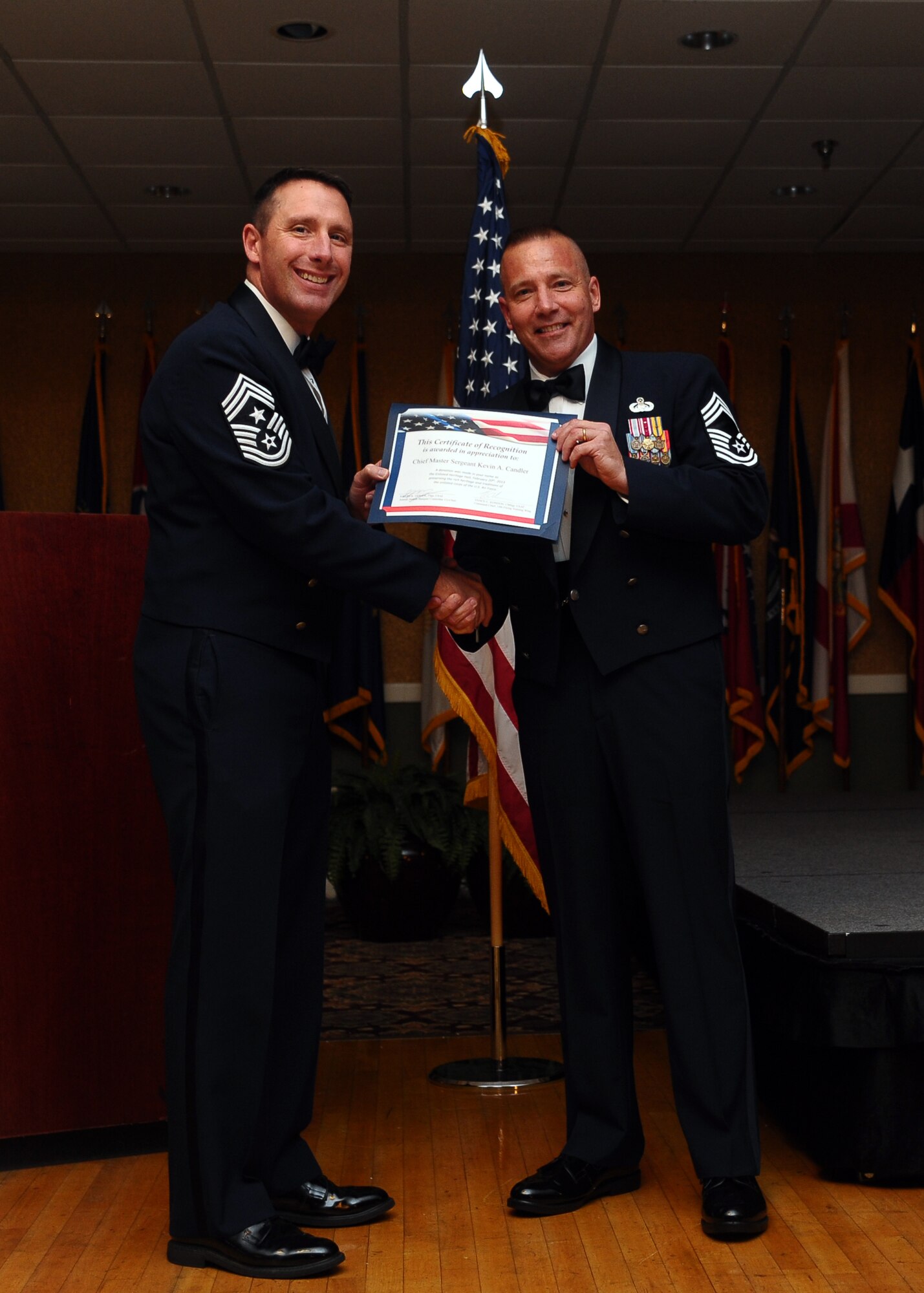 14th Flying Training Wing Command Chief Master Sergeant Vance Kondon presents Chief Master Sergeant Kevin Candler with a certificate of recognition for speaking at the 14th Flying Training Wing Annual Awards Banquet on Feb. 21. A donation to the Air Force Enlisted Heritage Hall was made in Candler’s name to show appreciation for his words of inspiration. (U.S. Air Force photo/Senior Airman Chase Hedrick)