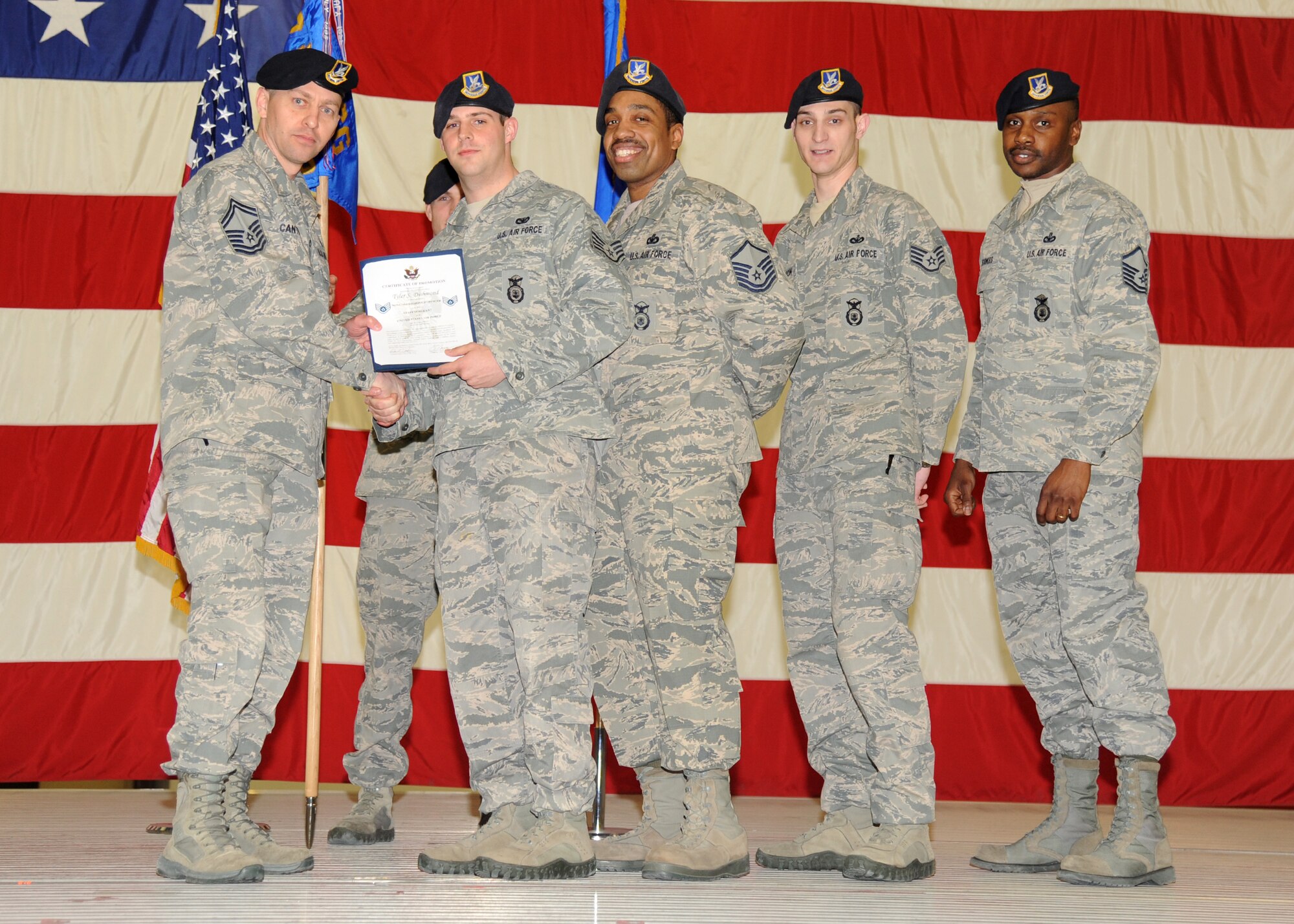 (Second from left) Staff Sgt. Tyler Dishmond is joined on stage by members of his unit, the 319th Security Forces Squadron, during a promotion ceremony on Feb. 28, 2013, on Grand Forks Air Force Base, N.D.  Dishmond is Grand Forks AFB’s Warrior of the Week for the last week of February 2013. (U.S. Air Force photo/ Airman 1st Class Xavier Navarro)