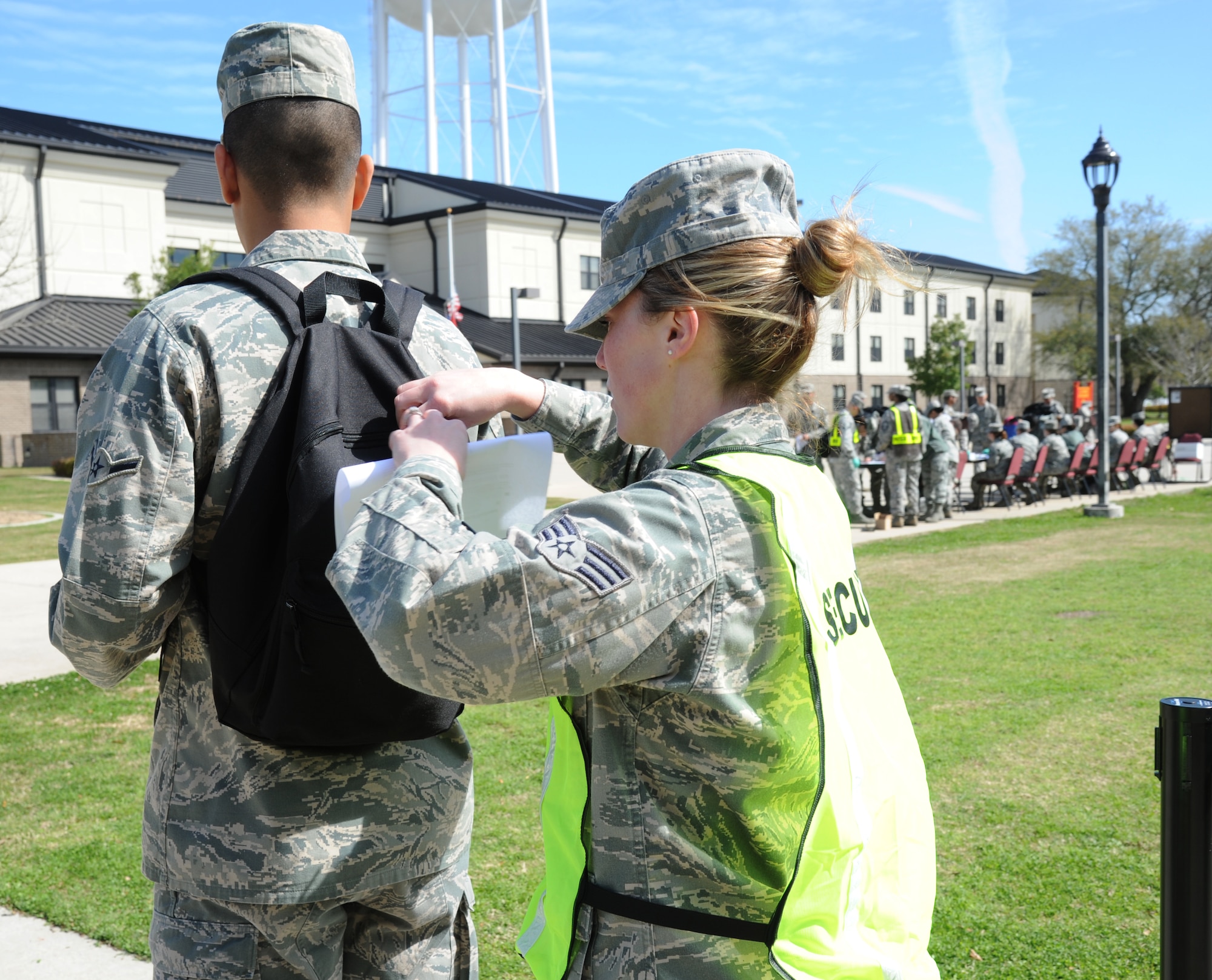 Airman Juan Lopez, 336th Training Squadron, has his backpack checked for security purposes by Senior Airman Kristy Boyd, 81st Diagnostic and Therapeutics Squadron, during a disease containment plan and point of dispensing exercise Feb. 28, 2013, near the Vandenburg Community Center, Keesler Air Force Base, Miss.  The scenario included a series of biological attacks in which numerous Keesler personnel became infected and the medical group had to distribute large quantities of medicine to efficiently minimize risk. (U.S. Air Force photo by Kemberly Groue)