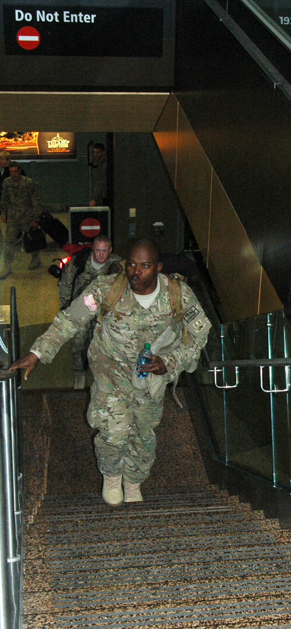 Tech. Sgt. Nathaniel Terrell and Senior Airman Travis Schween ascend the stairs at Seattle Tacoma International Airport to a welcoming group of family and friends. Terrell and Schween were just two of 13 Reserve Airmen who returned from Afghanistan Feb. 28. (U.S. Air Force photo by Sandra Pishner)
