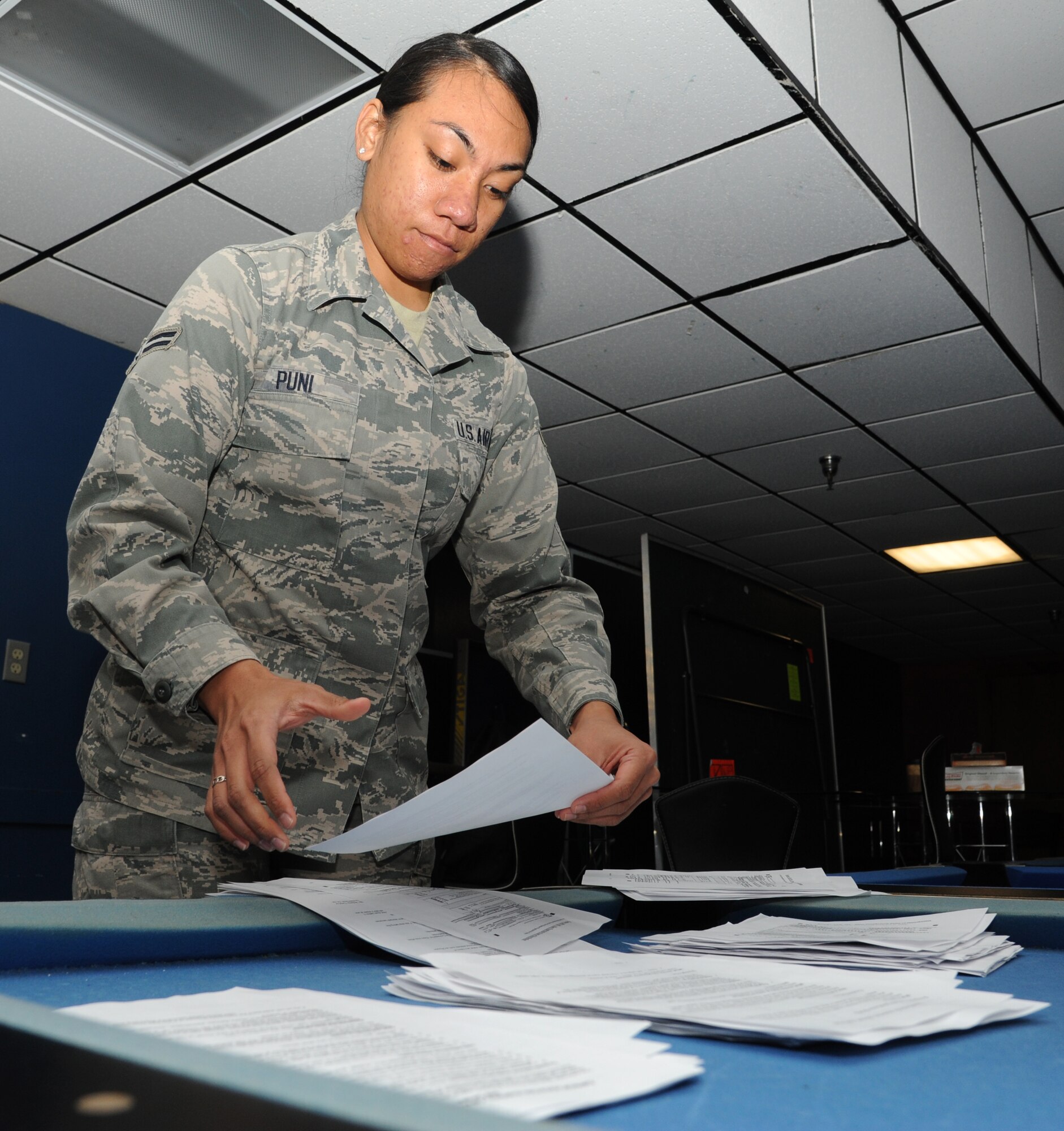 Airman 1st Class Athena Puni, 81st Medical Support Squadron, sorts out-processing forms during a disease containment plan and point of dispensing exercise Feb. 28, 2013, near the Vandenburg Community Center, Keesler Air Force Base, Miss.  The scenario included a series of biological attacks in which numerous Keesler personnel became infected and the medical group had to distribute large quantities of medicine to efficiently minimize risk. (U.S. Air Force photo by Kemberly Groue)