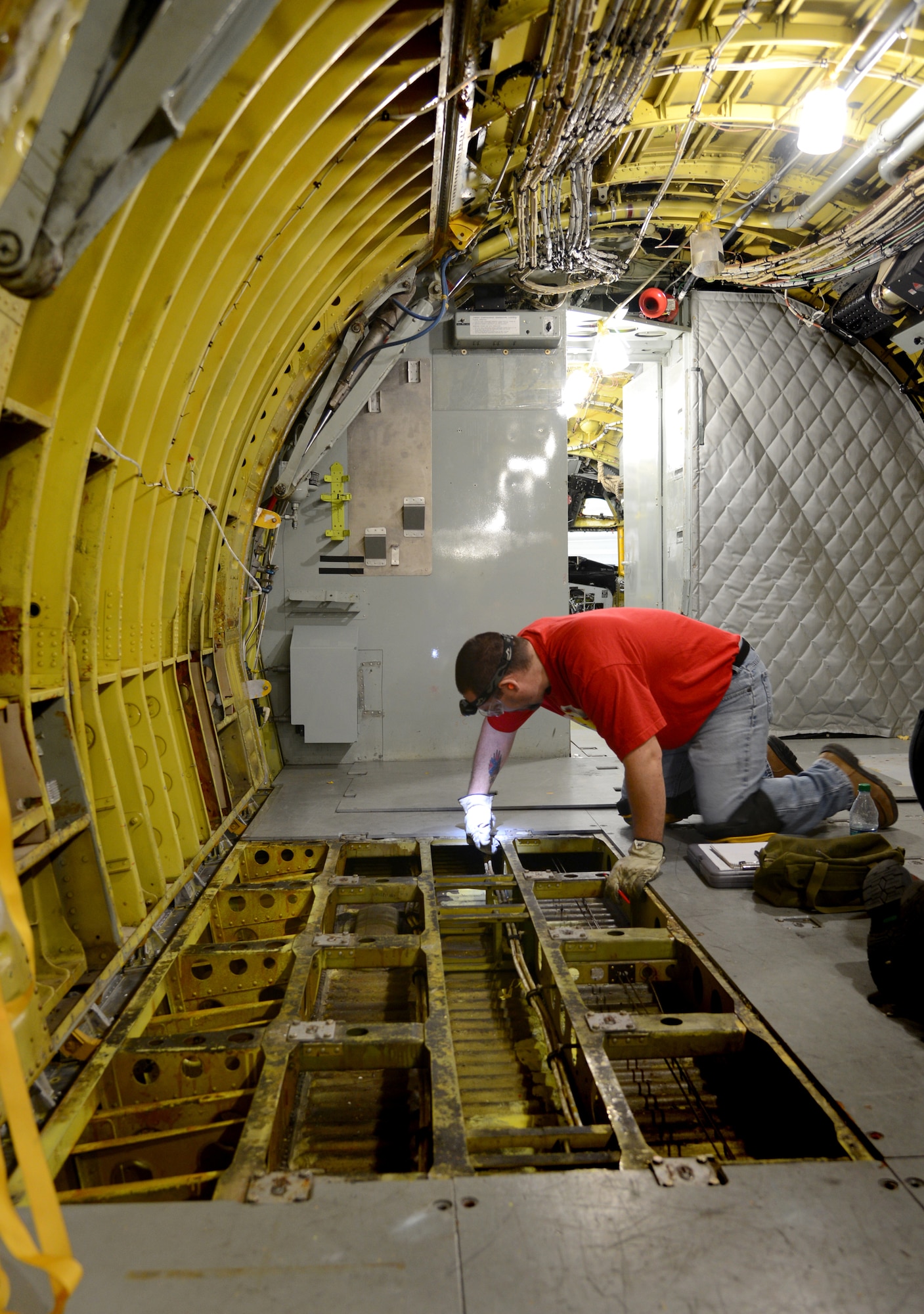 Robert Martin, a sheet metal mechanic with the 564th Aircraft Maintenance Squadron, examines the floors on a KC-135 Stratotanker in the Inspection Dock of Bldg. 2283. When all of the fabric in the walls, ceilings and floors of the aircraft is completely taken out, it will be thoroughly sprayed with a Corrosion Preventative Compound. This step will take approximately three days, compared to being scattered throughout the entirety of the aircraft’s maintenance schedule. (Air Force photos by Kelly White)
