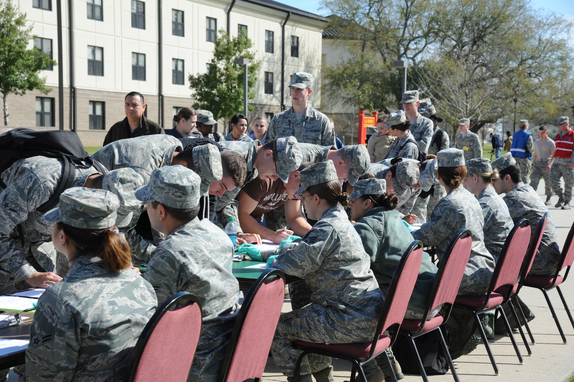 Dozens of Keesler personnel make their way through the patient administration table during a disease containment plan and point of dispensing exercise Feb. 28, 2013, near the Vandenburg Community Center, Keesler Air Force Base, Miss.  The scenario included a series of biological attacks in which numerous Keesler personnel became infected and the medical group had to distribute large quantities of medicine to efficiently minimize risk.  (U.S. Air Force photo by Kemberly Groue)