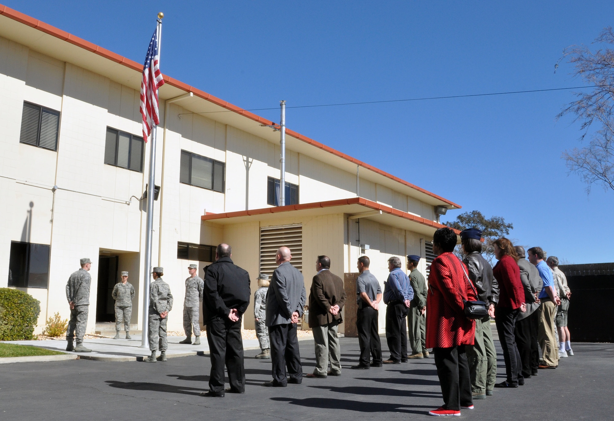 Honorary commanders face the flag and stand at parade rest while awaiting orders from the Airman Leadership School commandant, Master Sgt. Tanya Hubbard Feb. 21st during the honorary commander boot camp. (U.S. Air Force photo/Airman 1st Class Madelyn Brown).