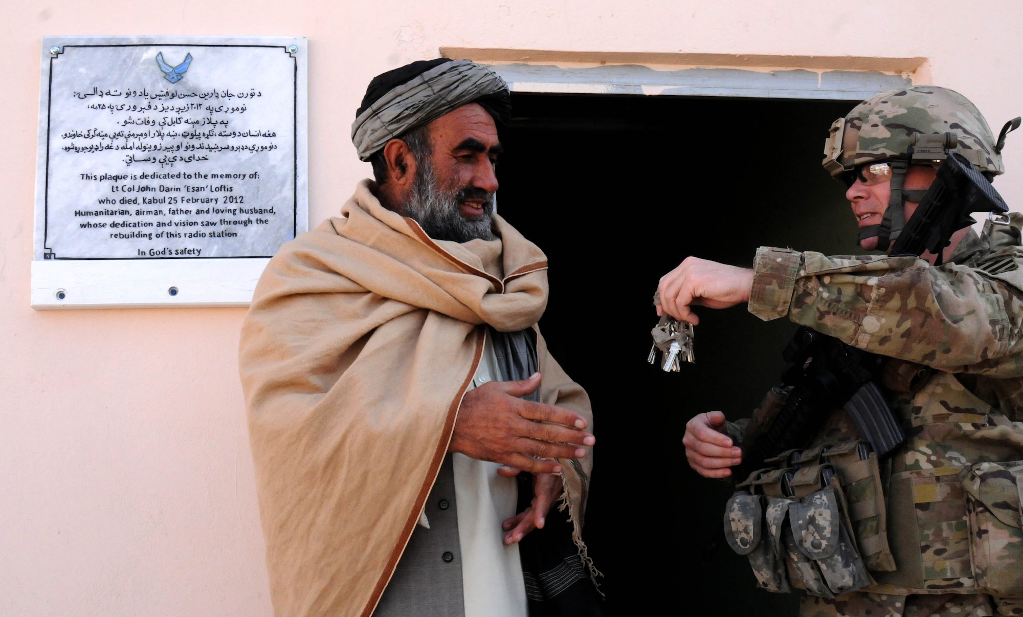 U.S. Air Force Lt. Col. Justin Kraft, commander of the Zabul Provincial Reconstruction Team, hands the keys to the newly complete Qalat radio station to Bismullah Lodin, a radio station official, during a ceremony in Qalat Afghanistan, Jan. 17. The radio station was dedicated in memory U.S. Air Force Lt. Col. John Darin Loftis, who died Feb. 25, 2012 from wounds received during an attack in Kabul. Loftis was a former member of Z PRT and instrumental in the development of the new radio station in Zabul Province. (U.S. Air Force Photo by Staff Sgt. Patrice Clarke)
