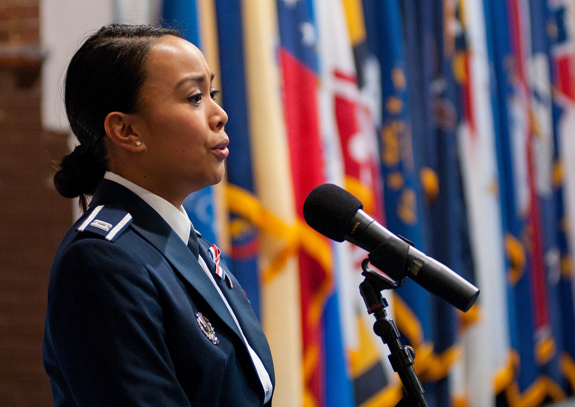 Capt. Kristine Poblete, 90th Operations Support Squadron, sings the National Anthem at the annual 90th Missile Wing awards banquet in the Fall Hall Community Center Feb. 22. (U.S. Air Force photo by R.J. Oriez)