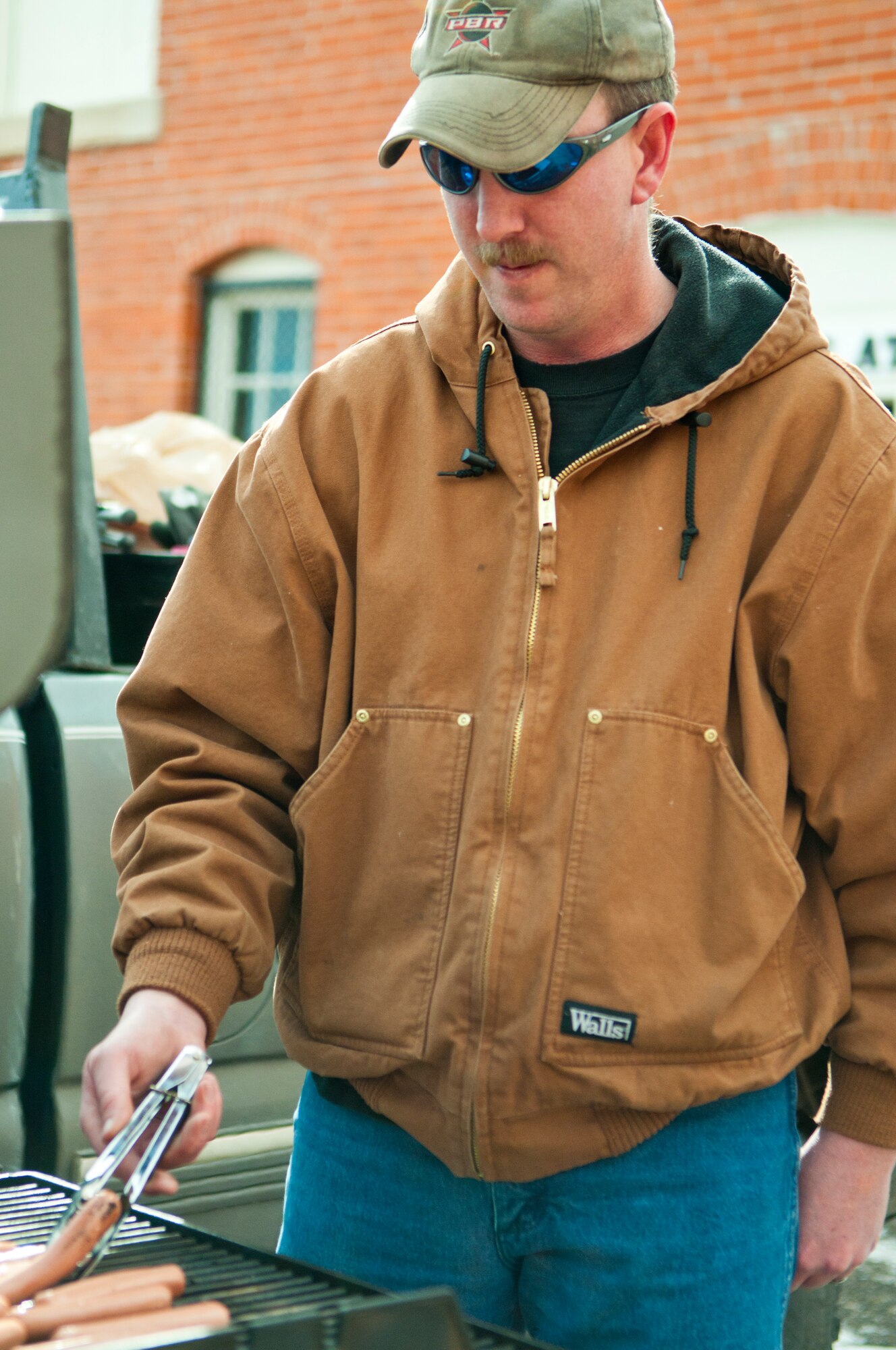 Staff Sgt. Cody Ferguson, 90th Munitions Squadron support section supervisor, grills hot dogs for those in attendance of the local Air Force Sergeants Association chapter’s membership drive held in the Airman’s Attic Feb 23. (U.S. Air Force photo by Airman 1st Class Jason Wiese)