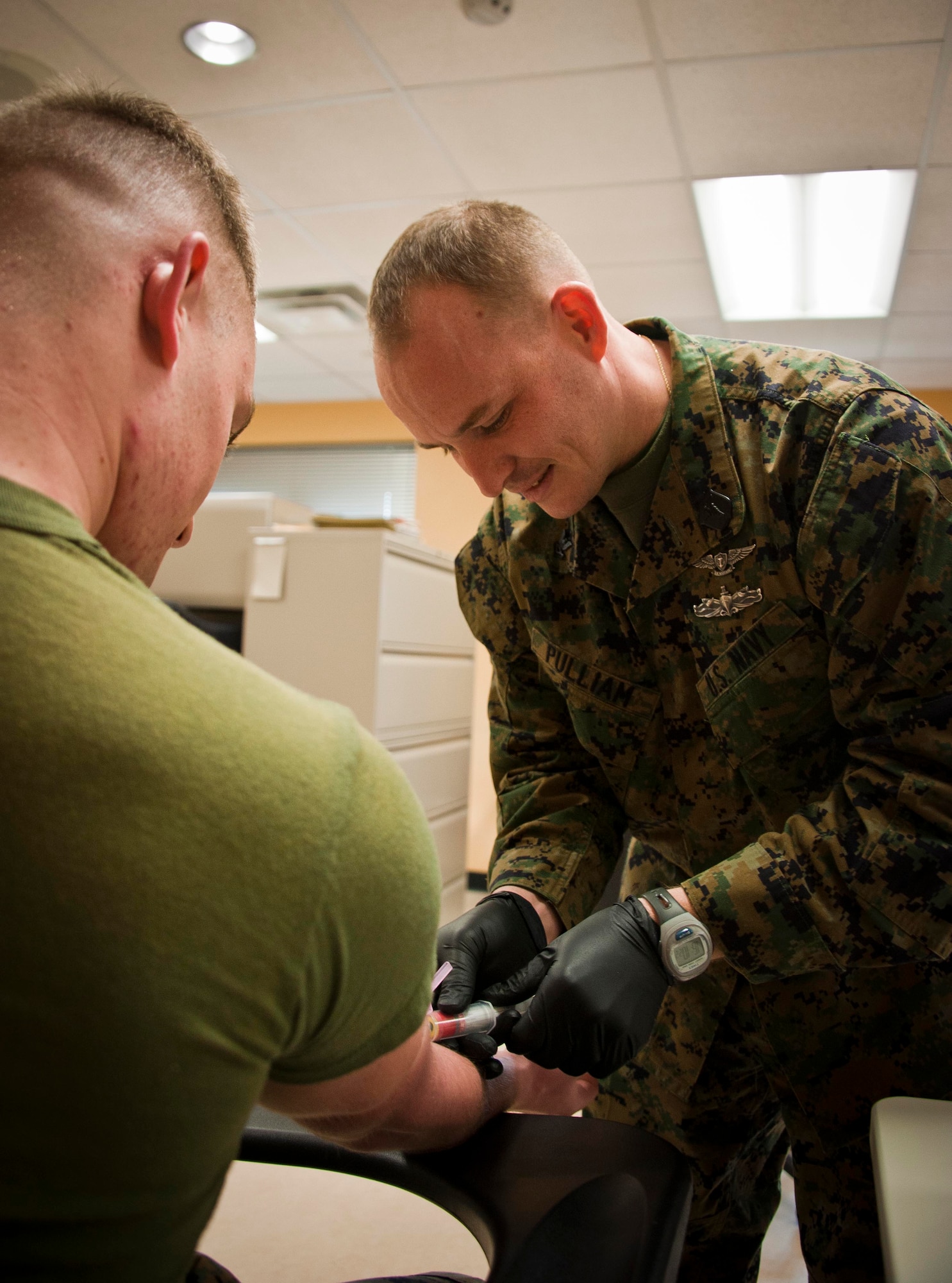 Petty Officer 2nd Class Joseph Pulliam, Marine Aircraft Group 49 hospital corpsman, takes a blood sample from Lance Cpl. Jordan Helsel, MAG-49 administrative specialist, Feb. 14, 2013, at the MAG-49 building on Joint Base McGuire-Dix-Lakehurst, N.J. A hospital corpsman is a Navy enlisted medical specialist who serves with Navy and Marine Corps units. (U.S. Air Force photo by Airman 1st Class Ryan Throneberry/Released)